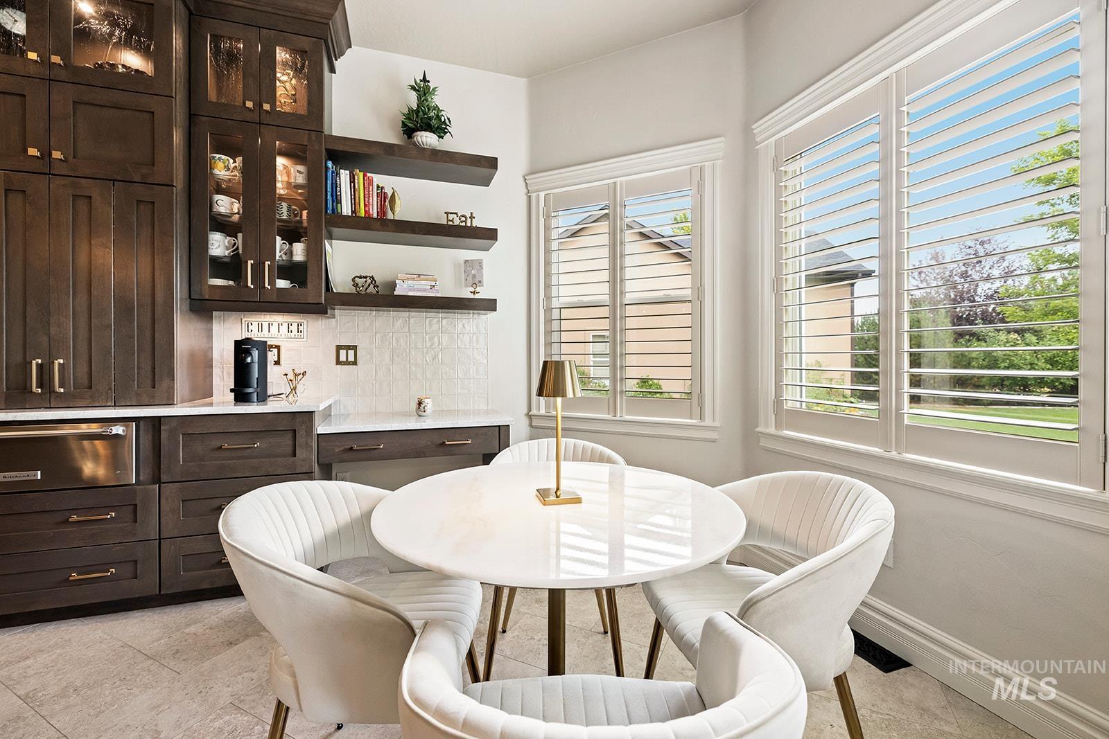 Dining space with light tile patterned flooring and baseboards
