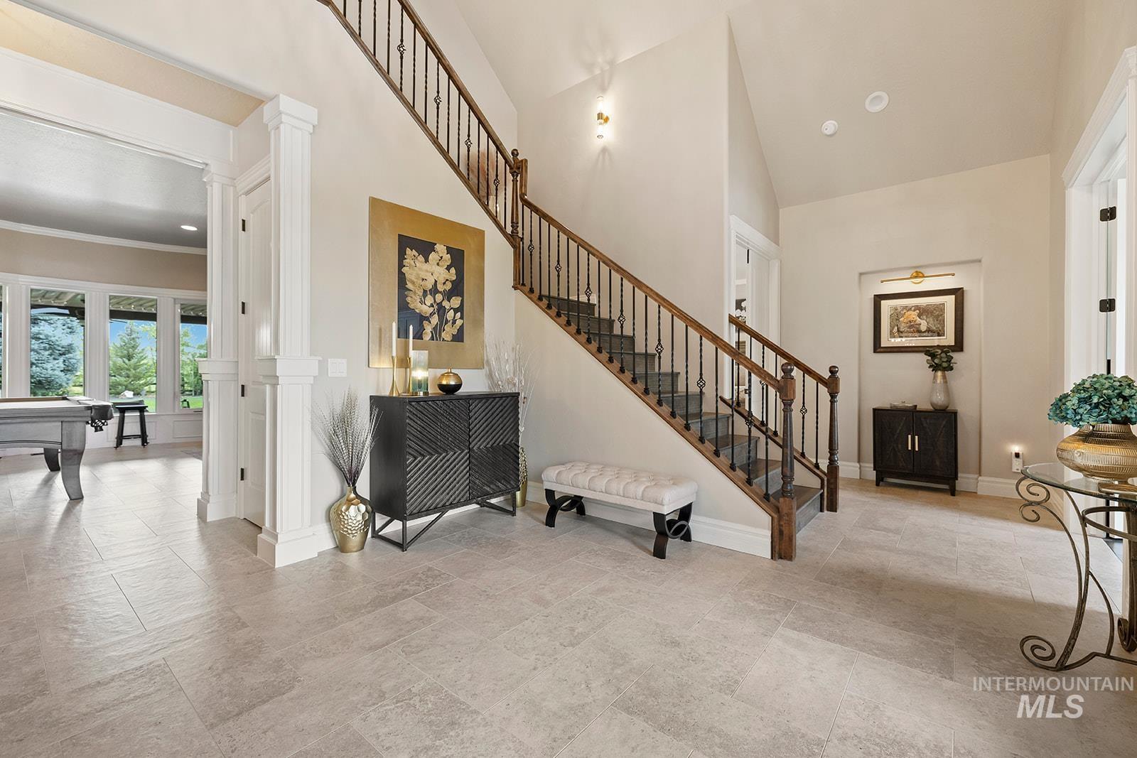 Entryway with decorative columns and high vaulted ceiling
