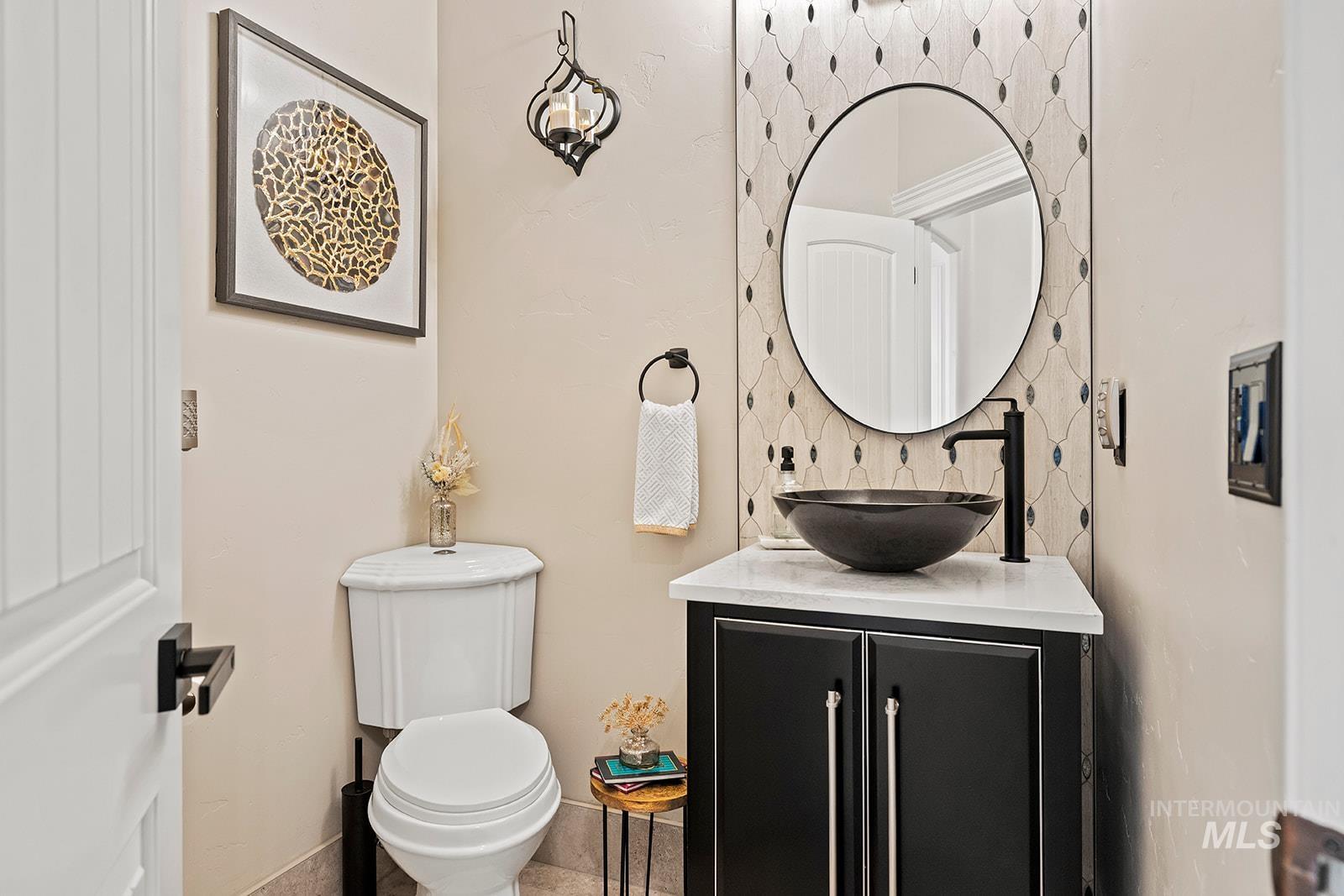 Bathroom with vanity and tasteful backsplash