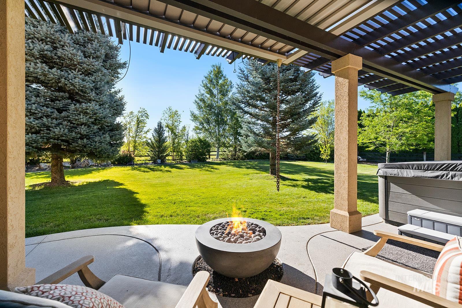 View of patio featuring a pergola and an outdoor fire pit