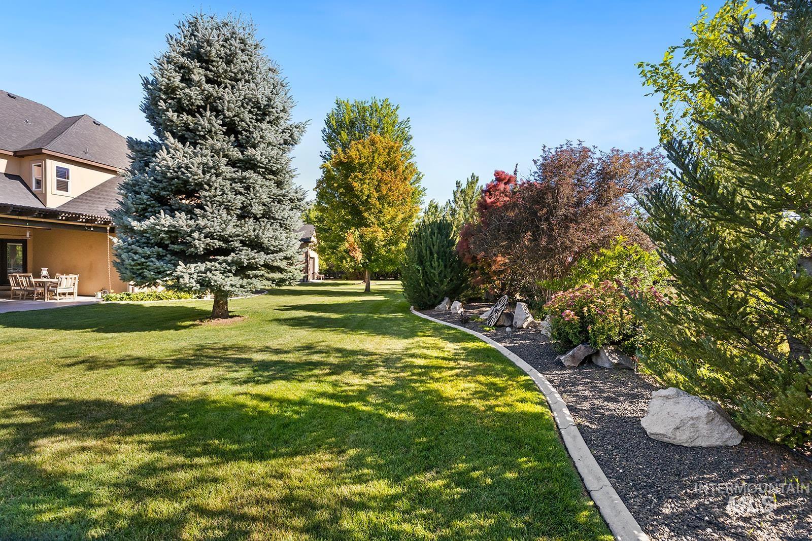View of grassy yard with a patio area