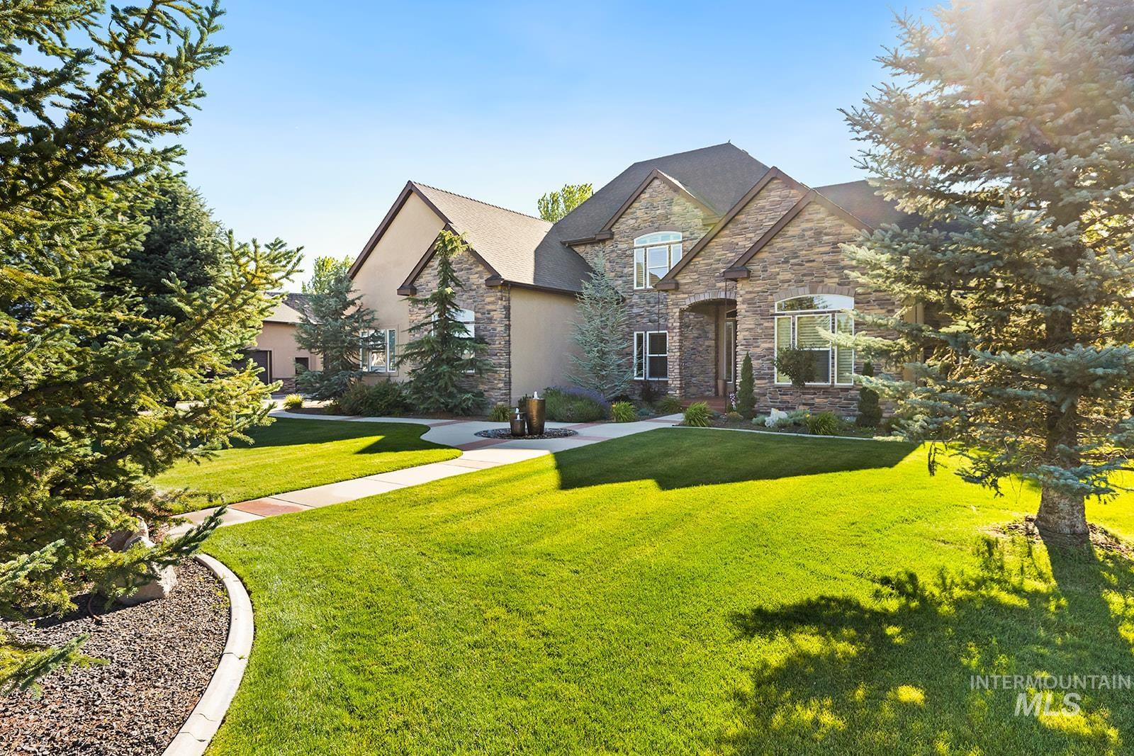 French country inspired facade with a front lawn and stone siding