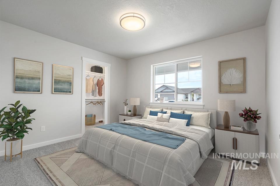 Bedroom featuring carpet and a walk in closet