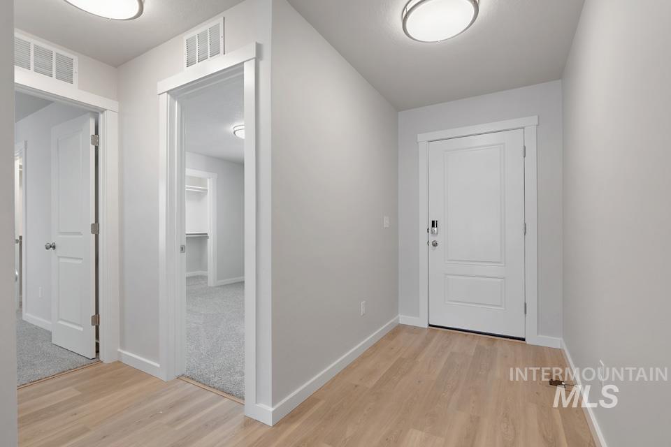Hall featuring light wood-type flooring and baseboards