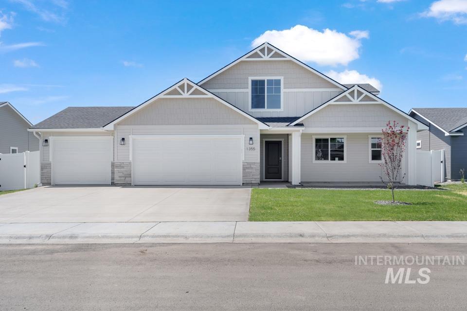 Craftsman house featuring driveway, an attached garage, and stone siding