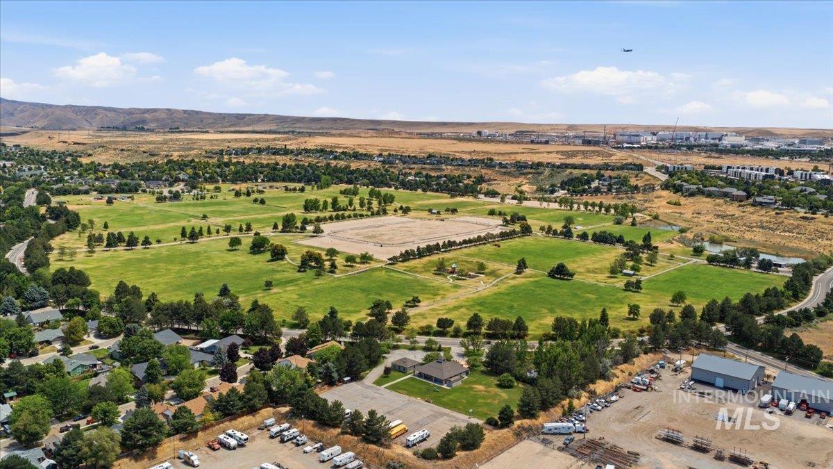 Expansive green spaces and mature trees define this substantial park area, bordered by residential properties