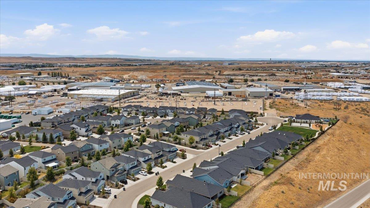 Aerial overview showcasing a residential development with numerous single-family homes, paved streets, and green landscaping