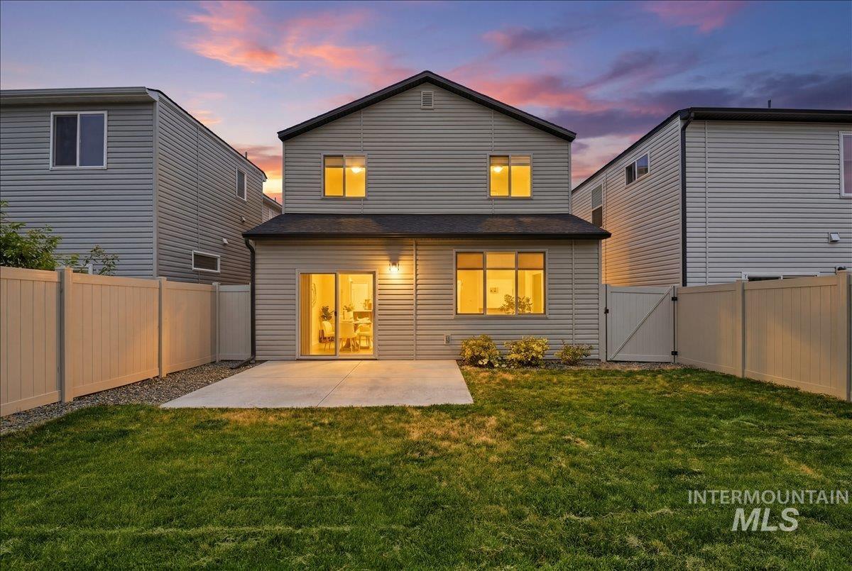 Rear exterior featuring a concrete patio, sliding glass door, and vinyl siding
