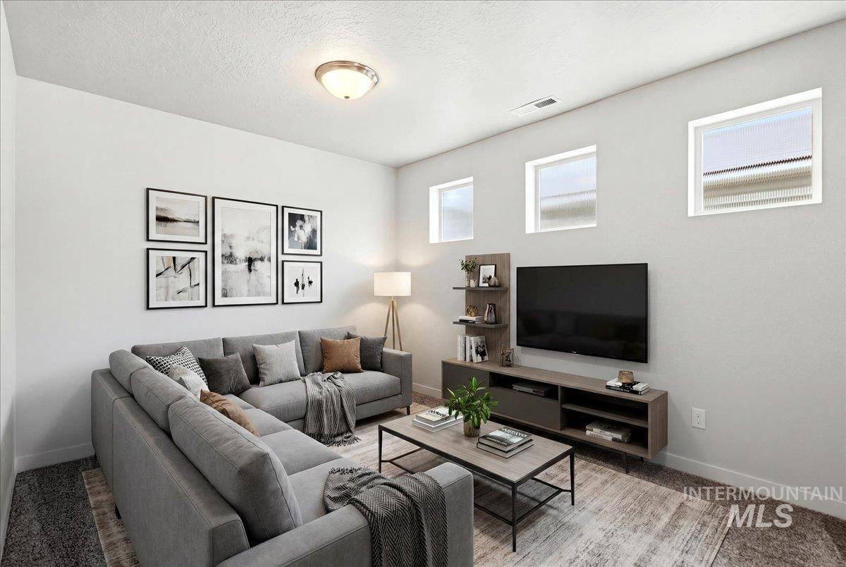 Bright living area featuring a ceiling-mounted light fixture, light gray walls, and multiple rectangular windows