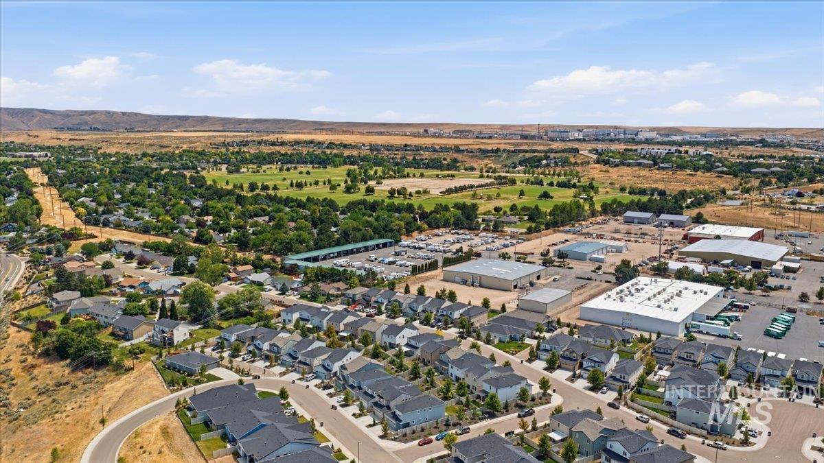 Expansive aerial perspective showcasing a residential development with numerous single-family homes featuring dark-toned roofs