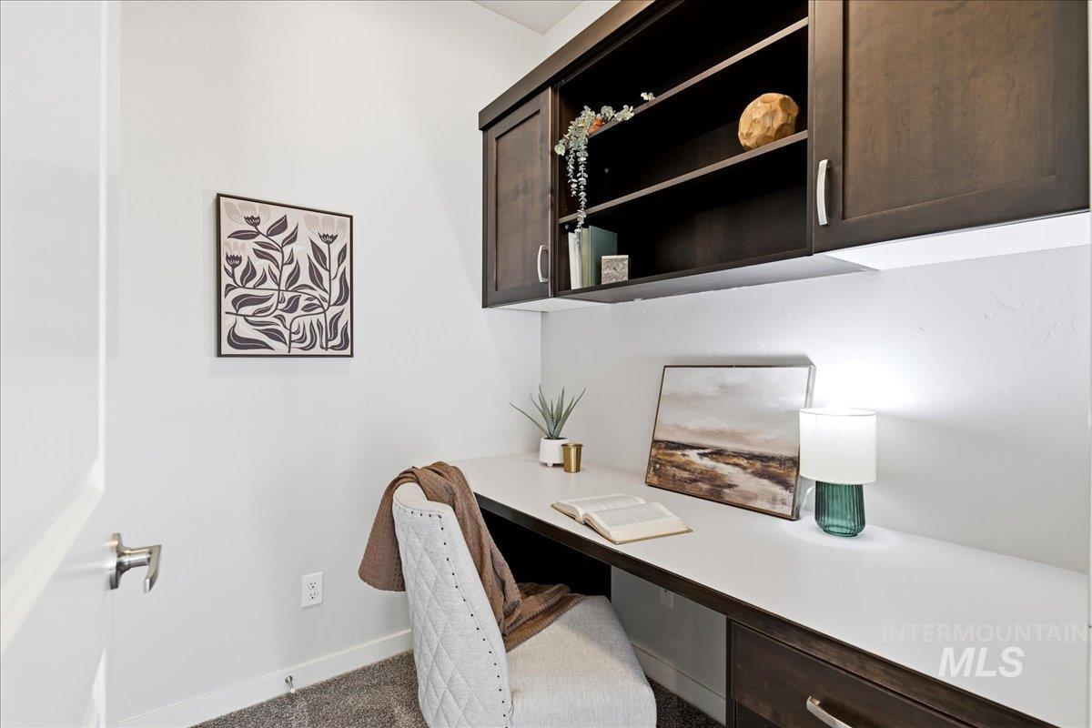 Built-in desk featuring a white surface and dark wood-finish cabinetry