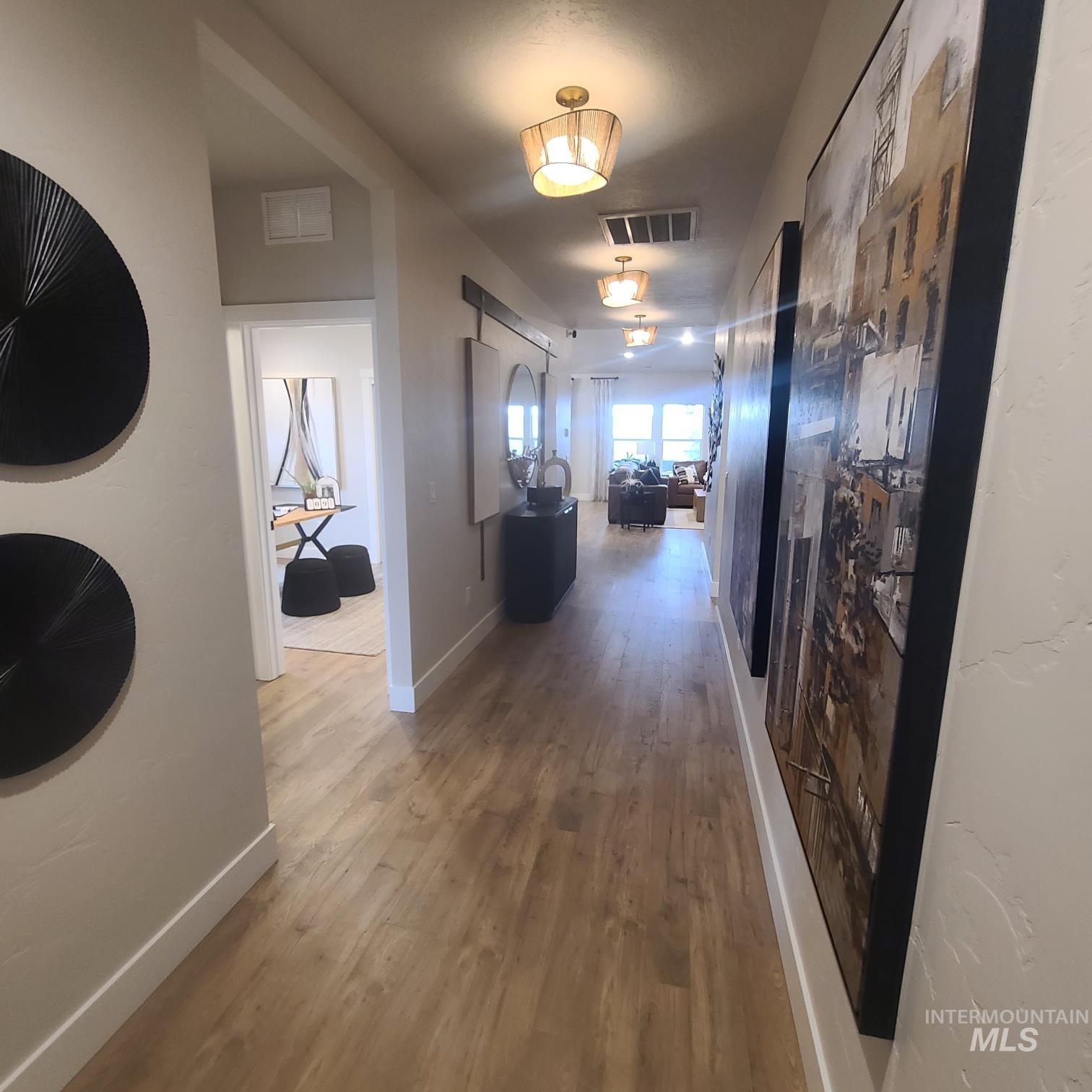 Hall with light wood-type flooring and baseboards