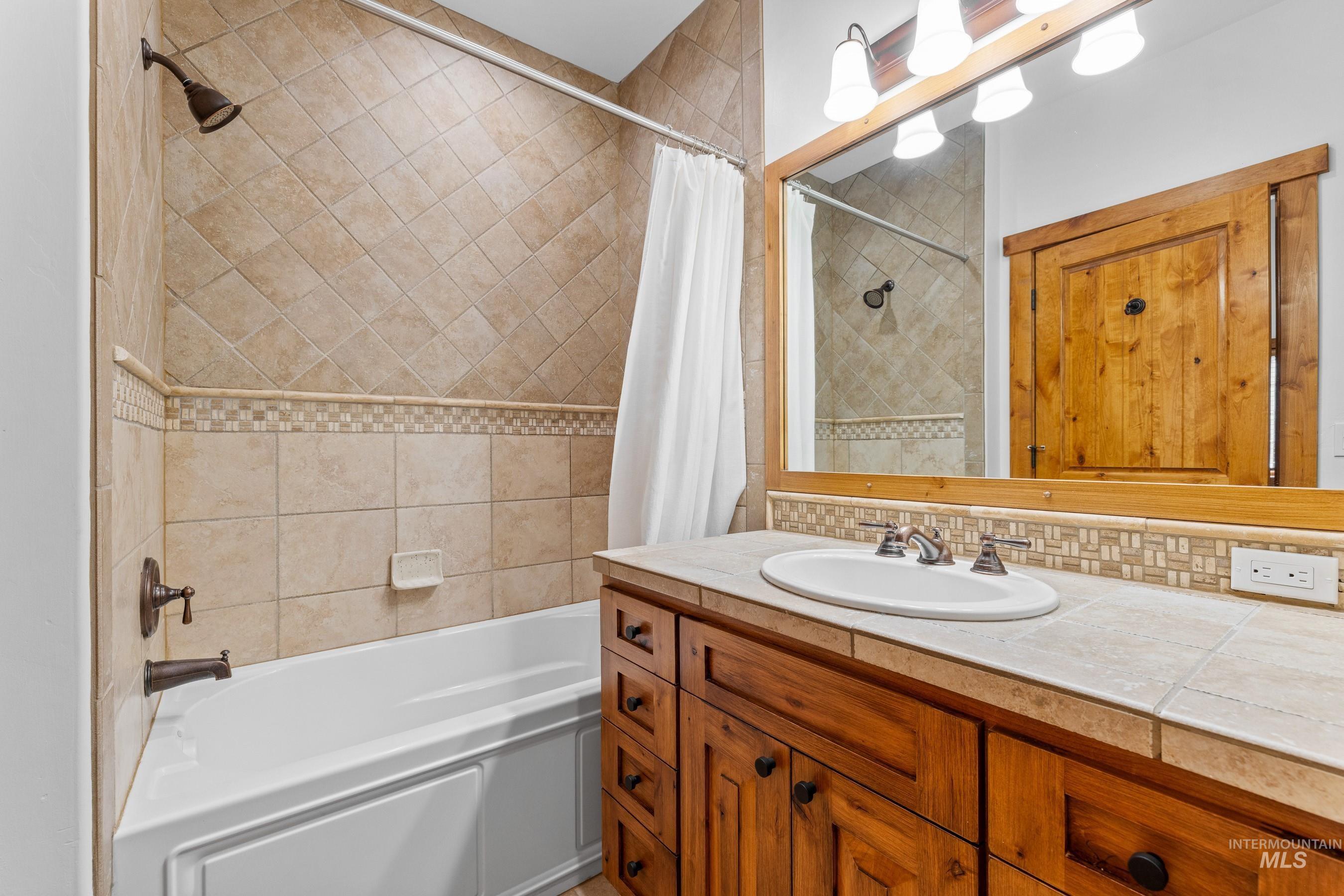 Bathroom featuring shower / bath combo with shower curtain and vanity