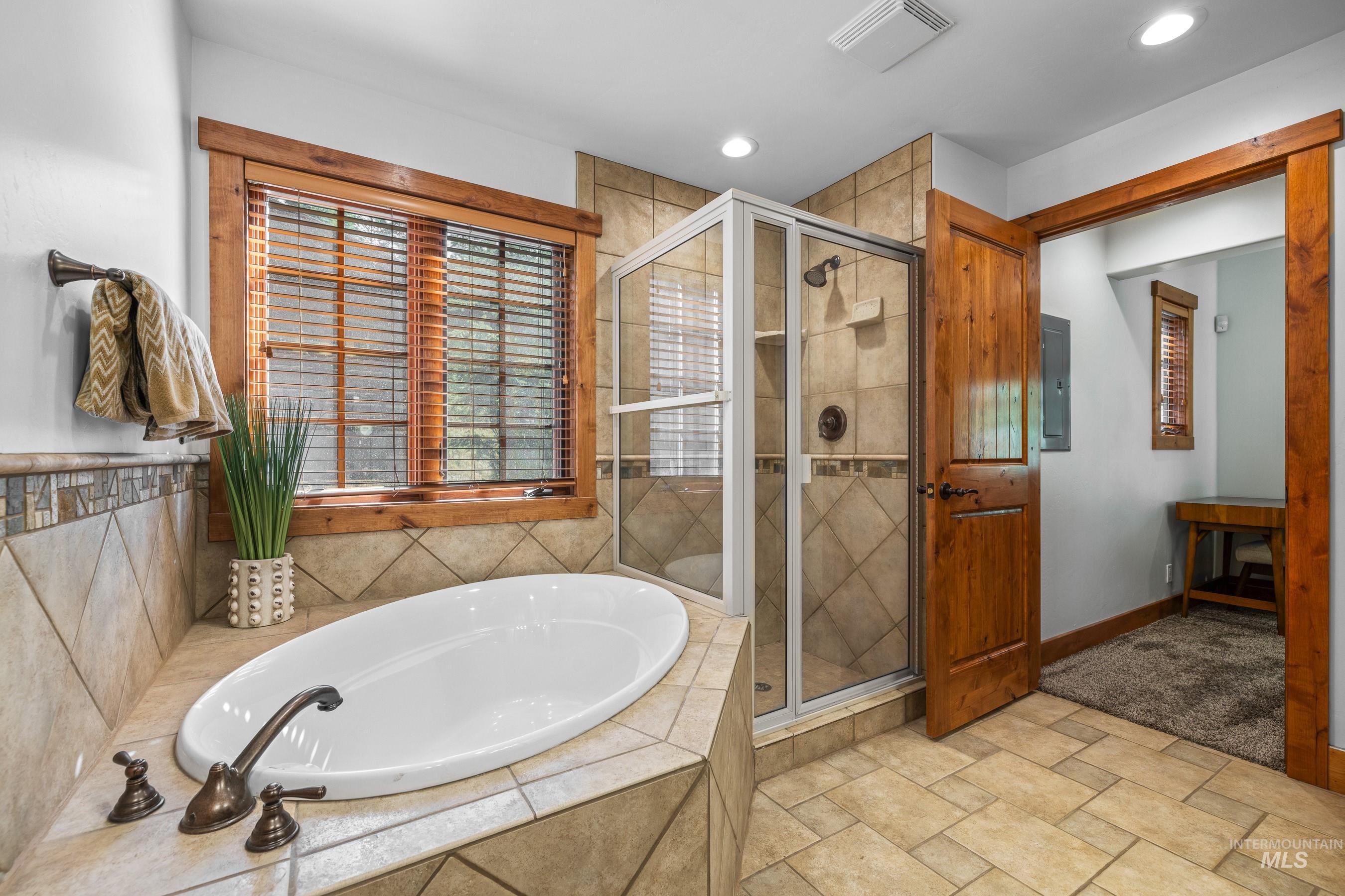 Bathroom featuring a shower stall and tub