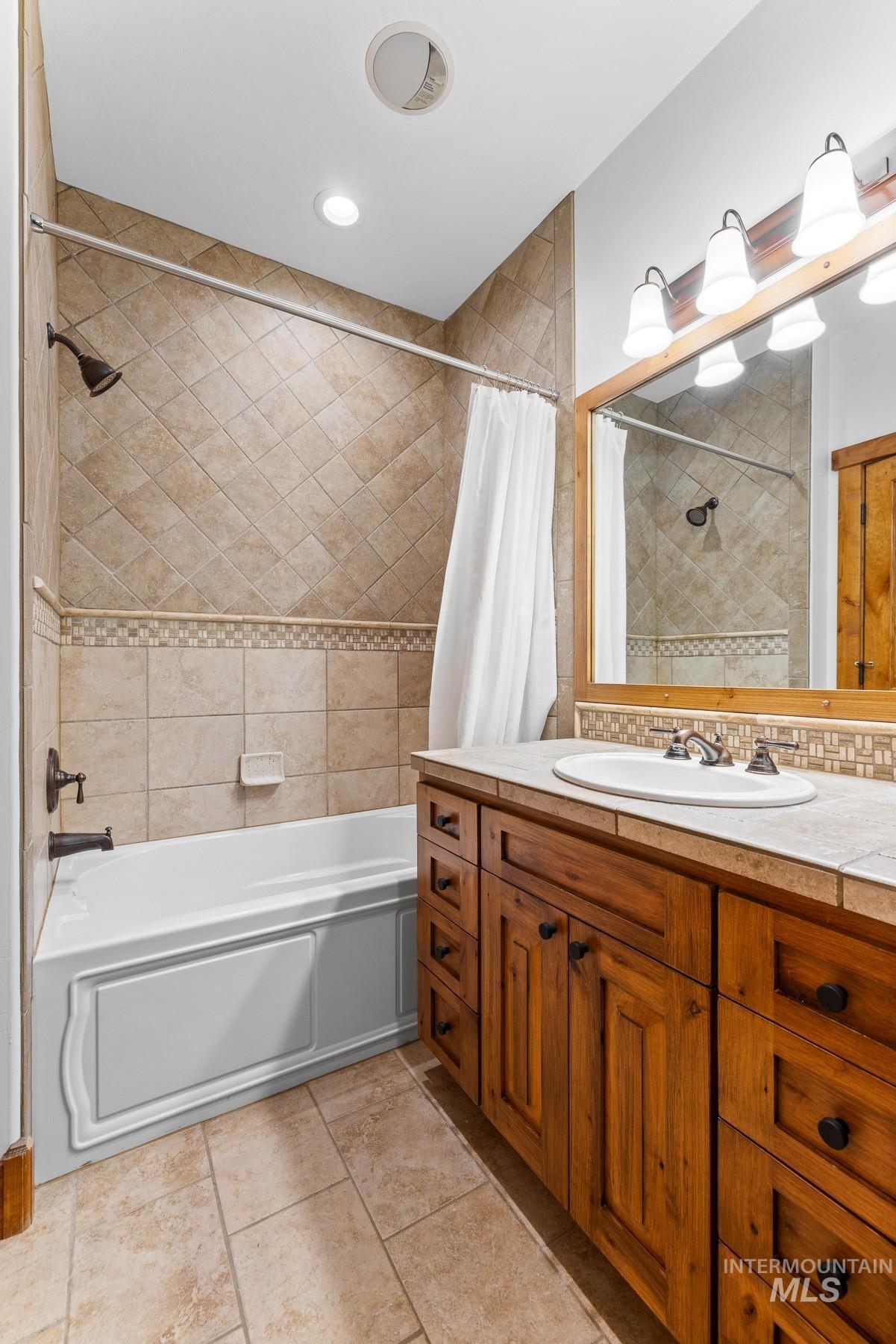 Full bath featuring shower / bath combo and vanity