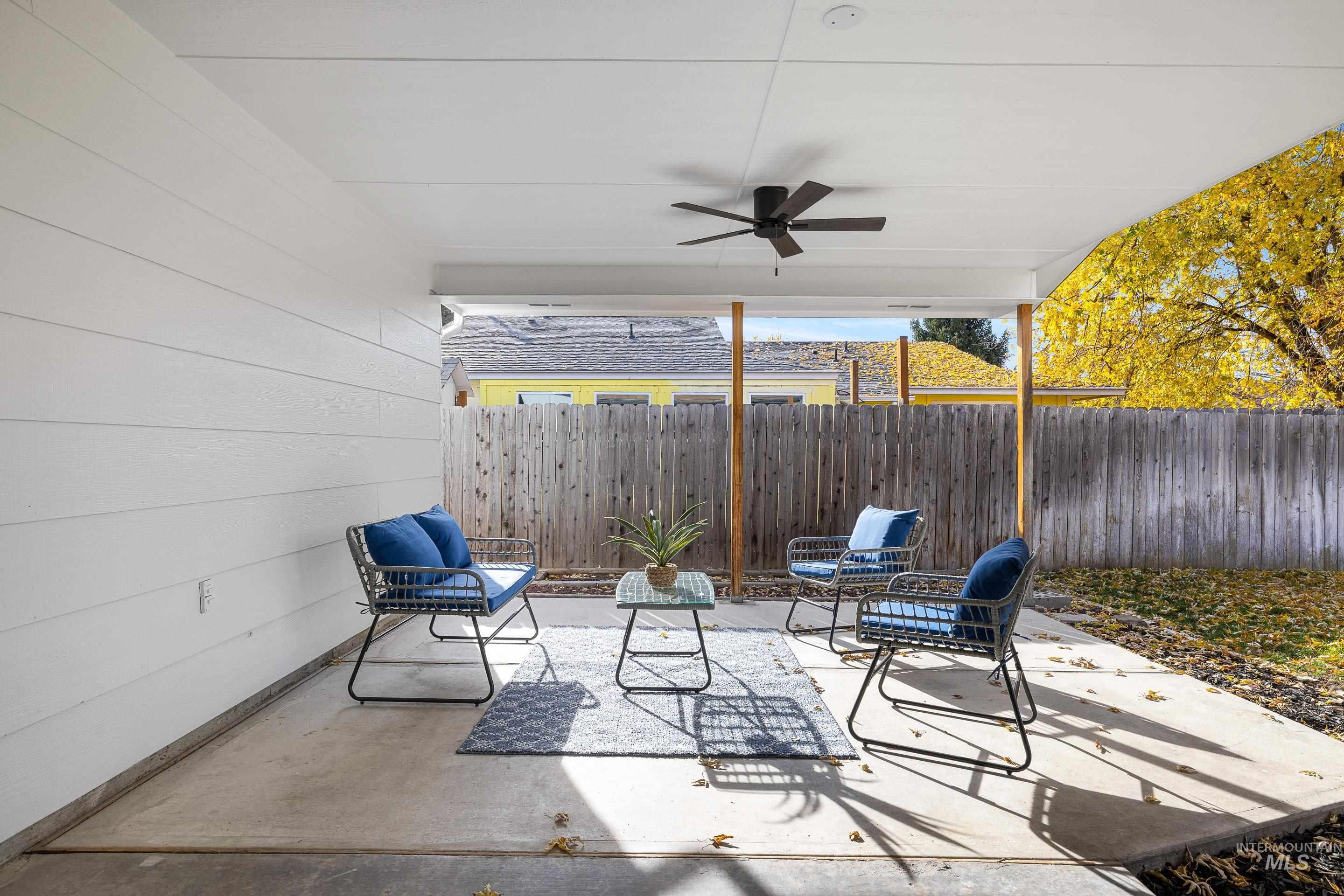 Fenced backyard with a patio and ceiling fan