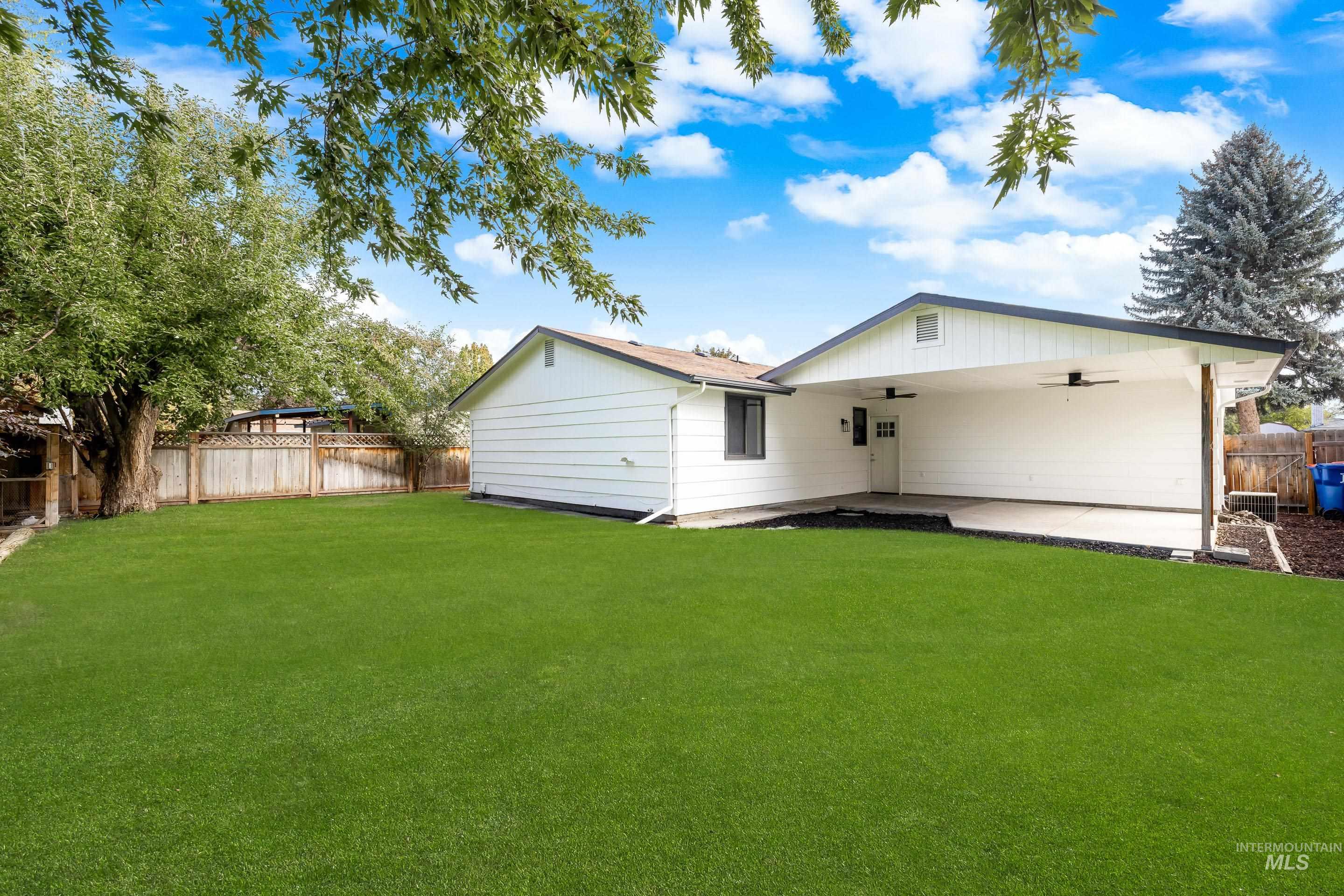 Rear view of property with a ceiling fan, a fenced backyard, and a patio area