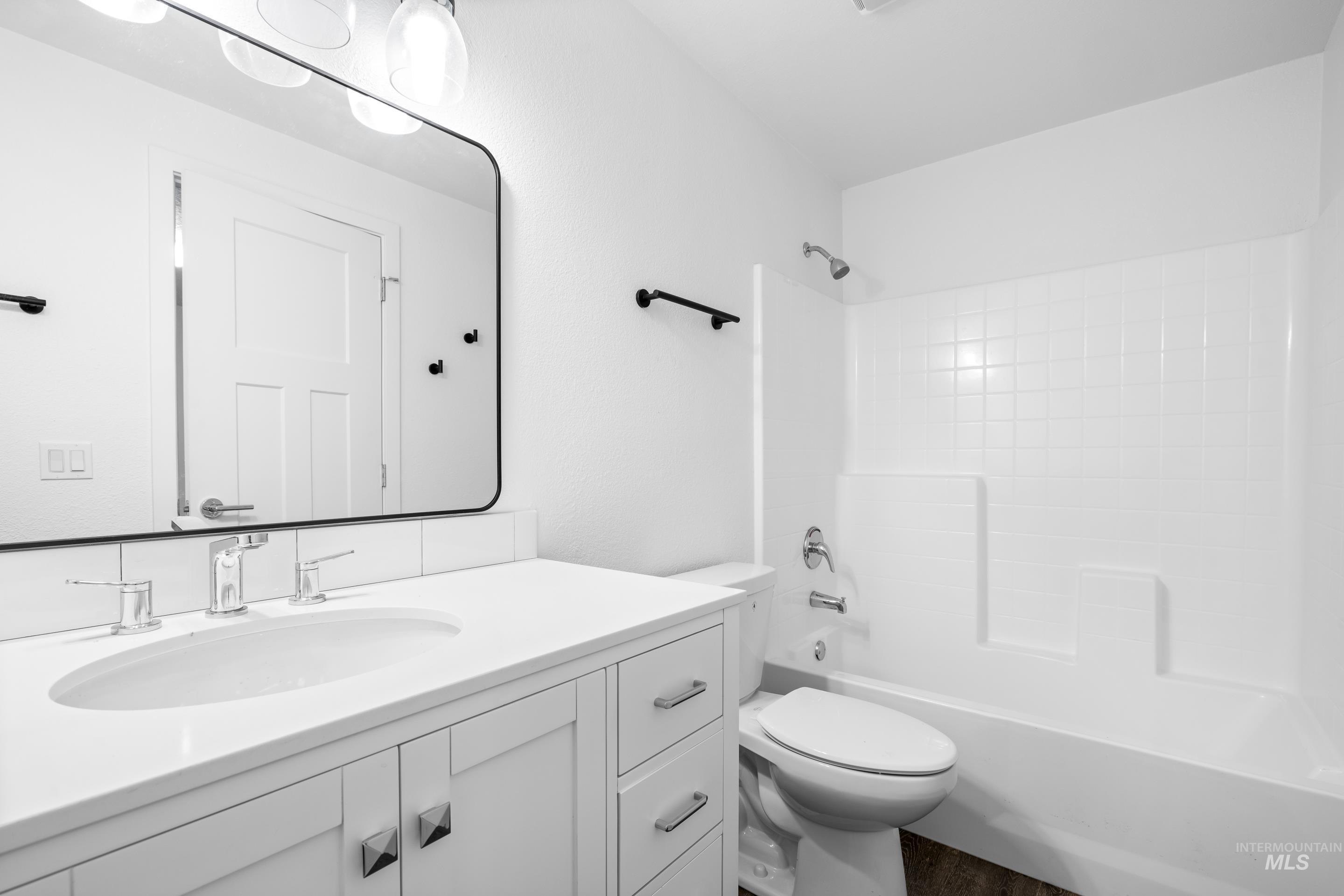 Bathroom with shower / bath combination, vanity, and wood finished floors