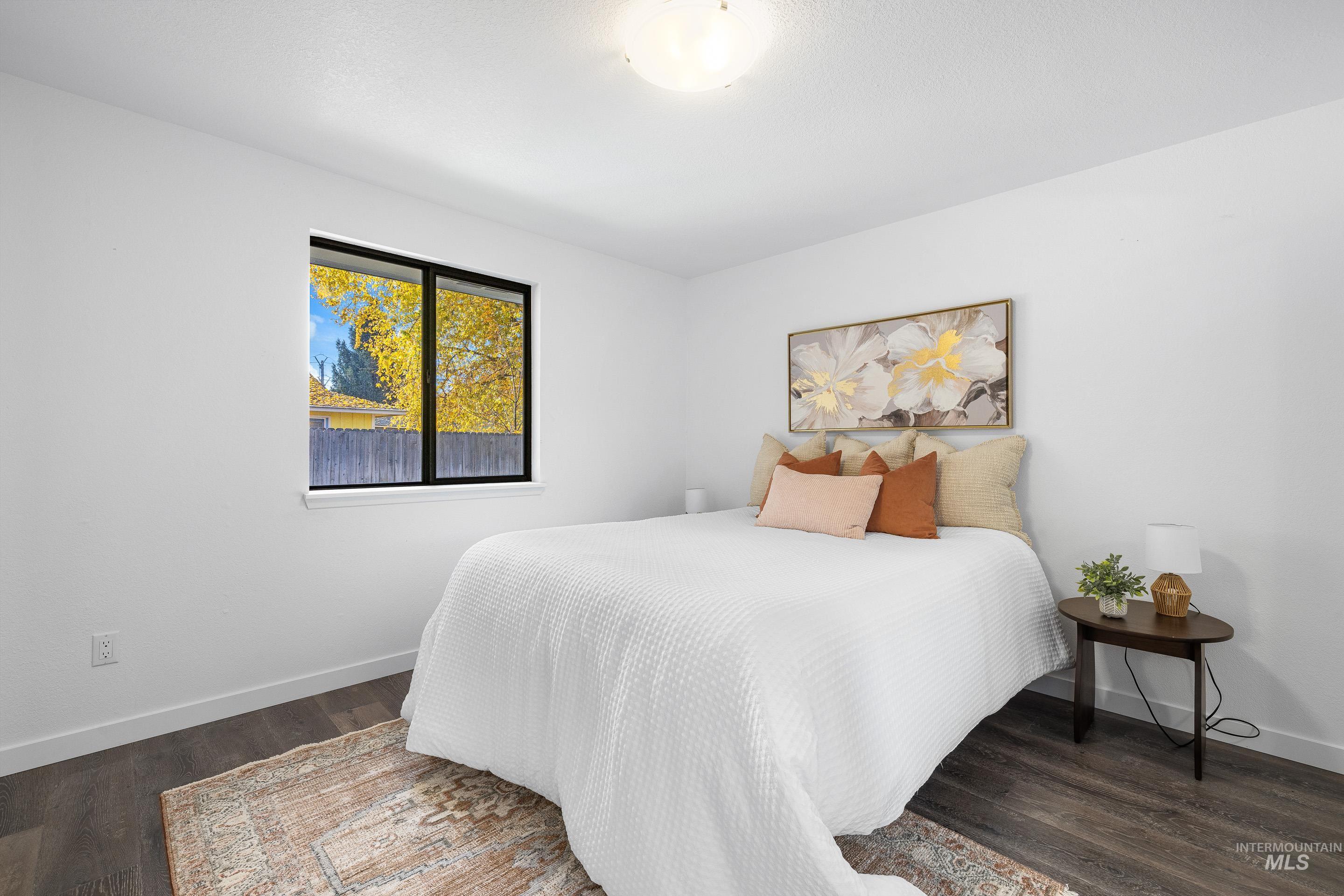 Bedroom with baseboards and dark wood-type flooring