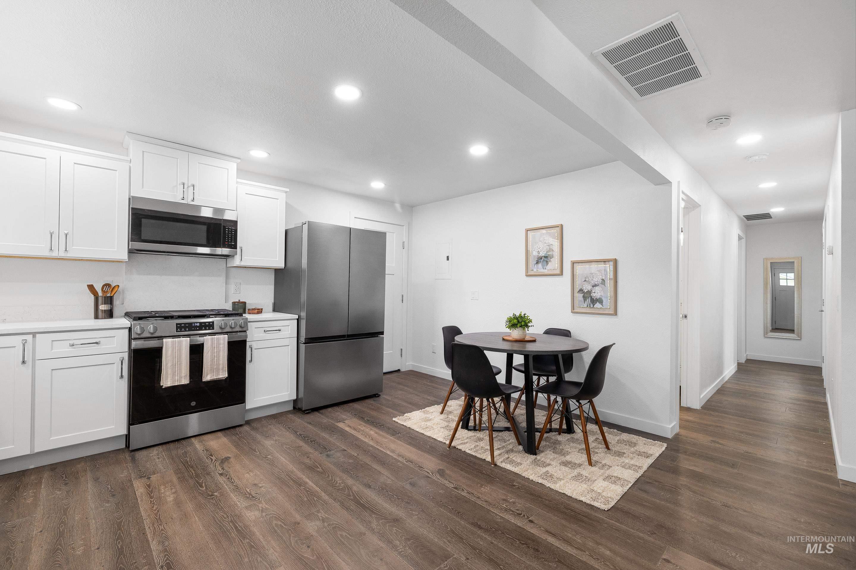 Kitchen featuring white cabinets, appliances with stainless steel finishes, light countertops, and recessed lighting
