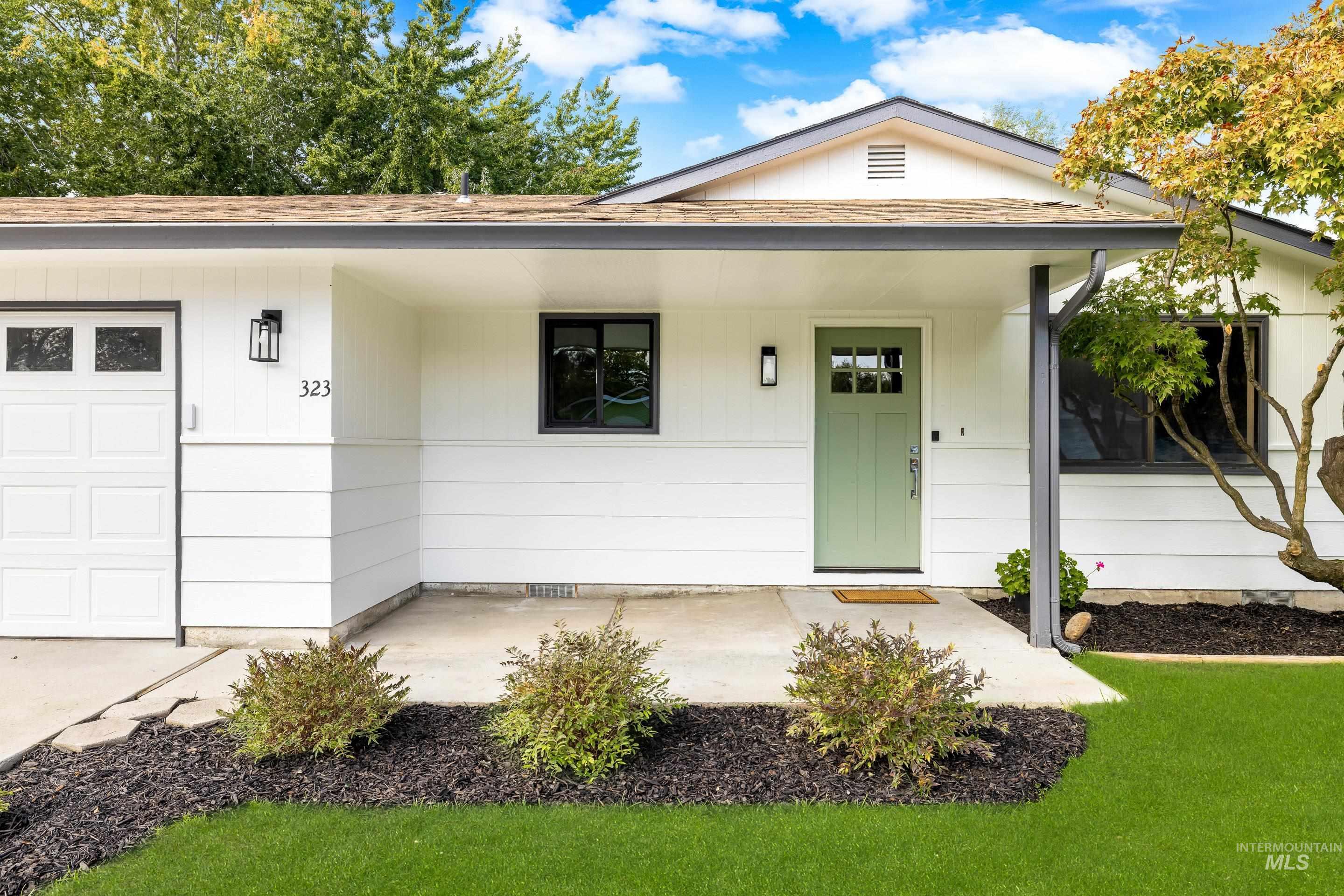 View of front facade with roof with shingles, a porch, an attached garage, and a front lawn
