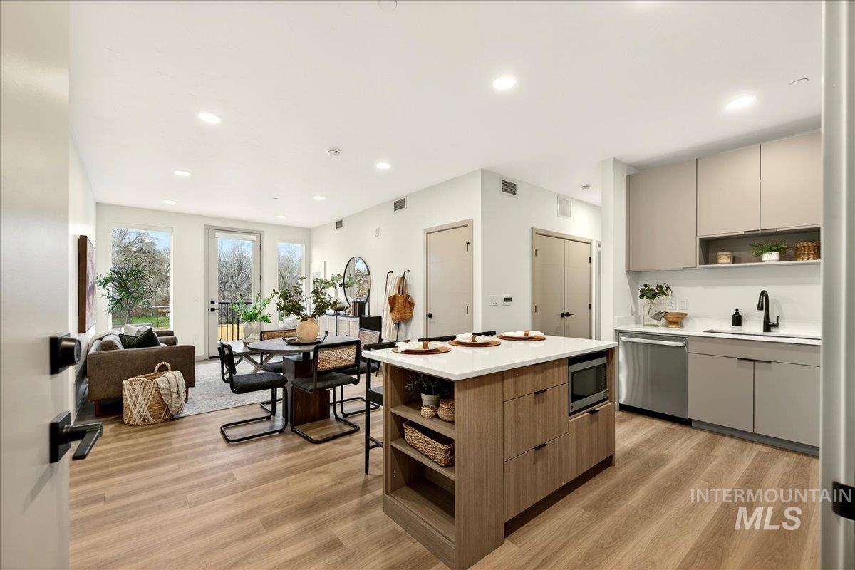 Kitchen with open shelves, modern cabinets, a kitchen island, light wood finished floors, and recessed lighting
