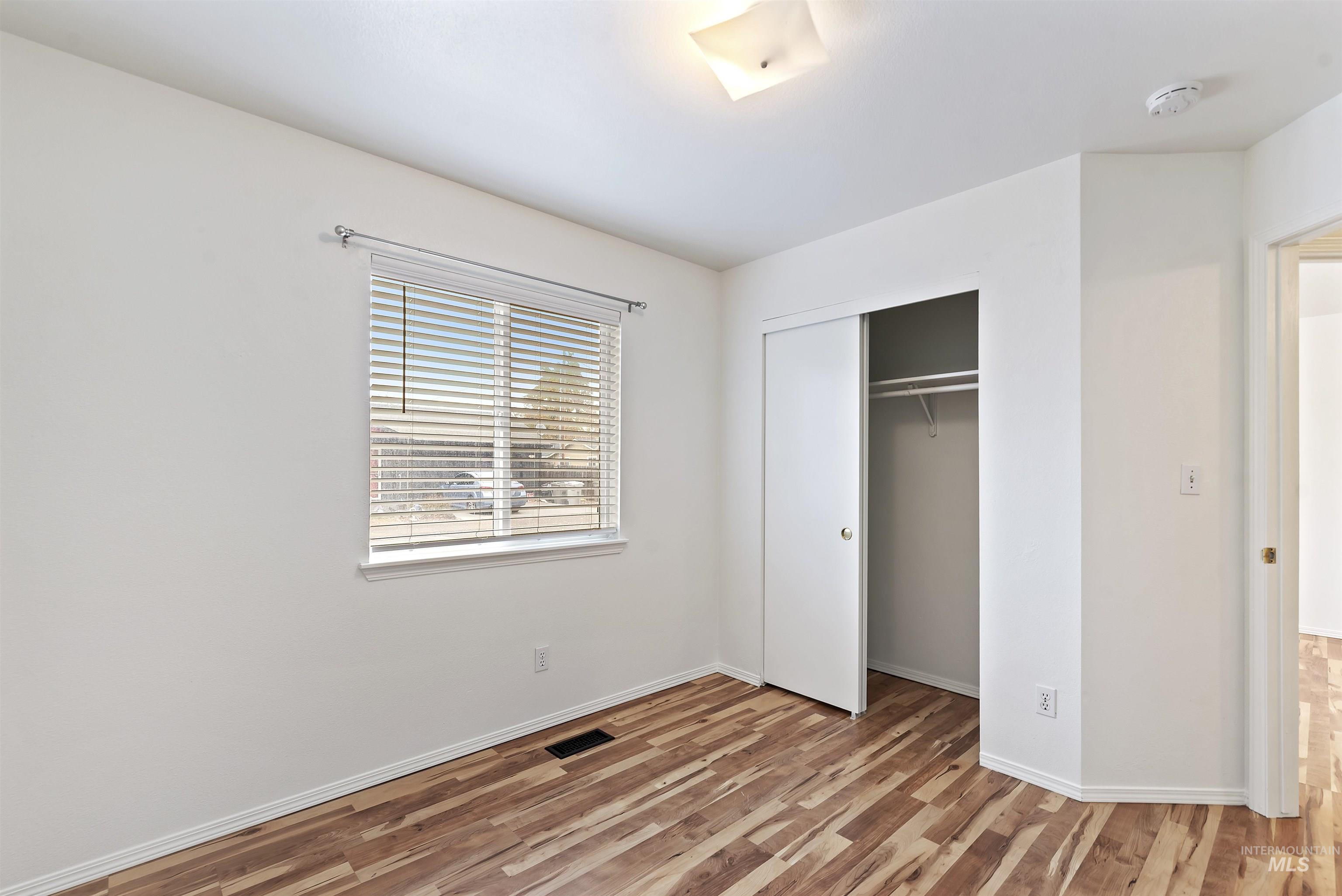 Unfurnished bedroom featuring light wood-type flooring and a closet