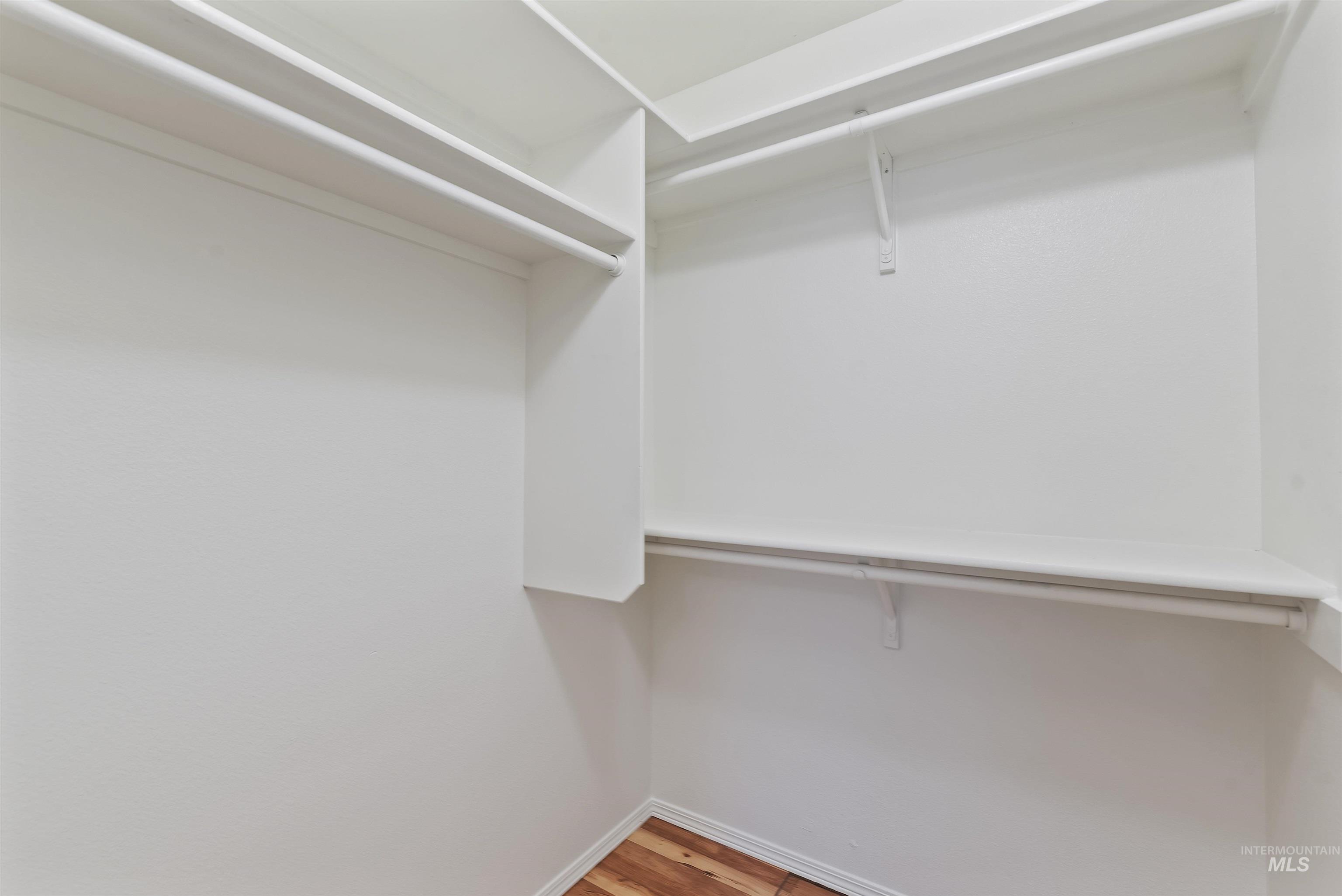 Walk in closet with light wood finished floors