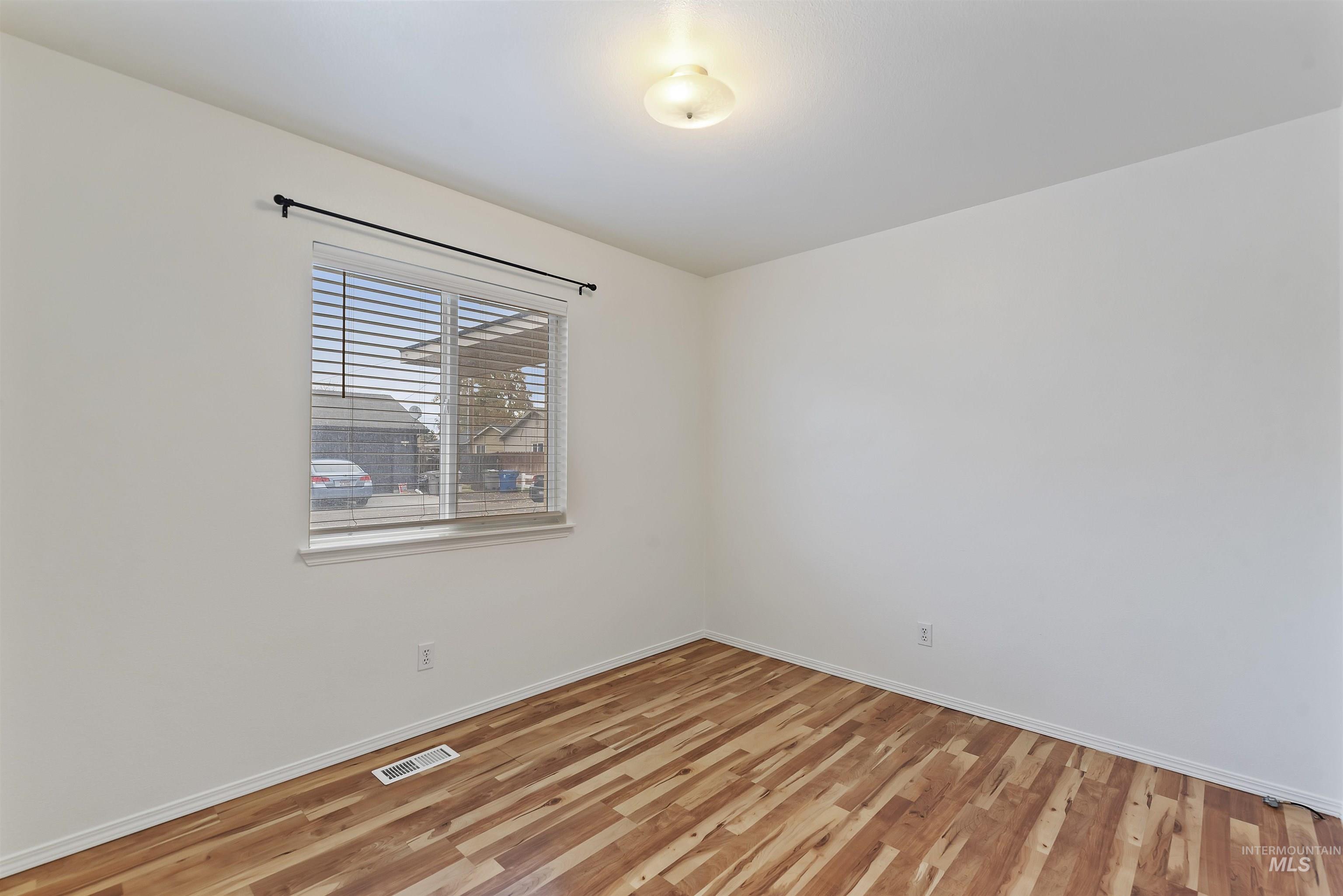 Spare room featuring light wood-type flooring and baseboards