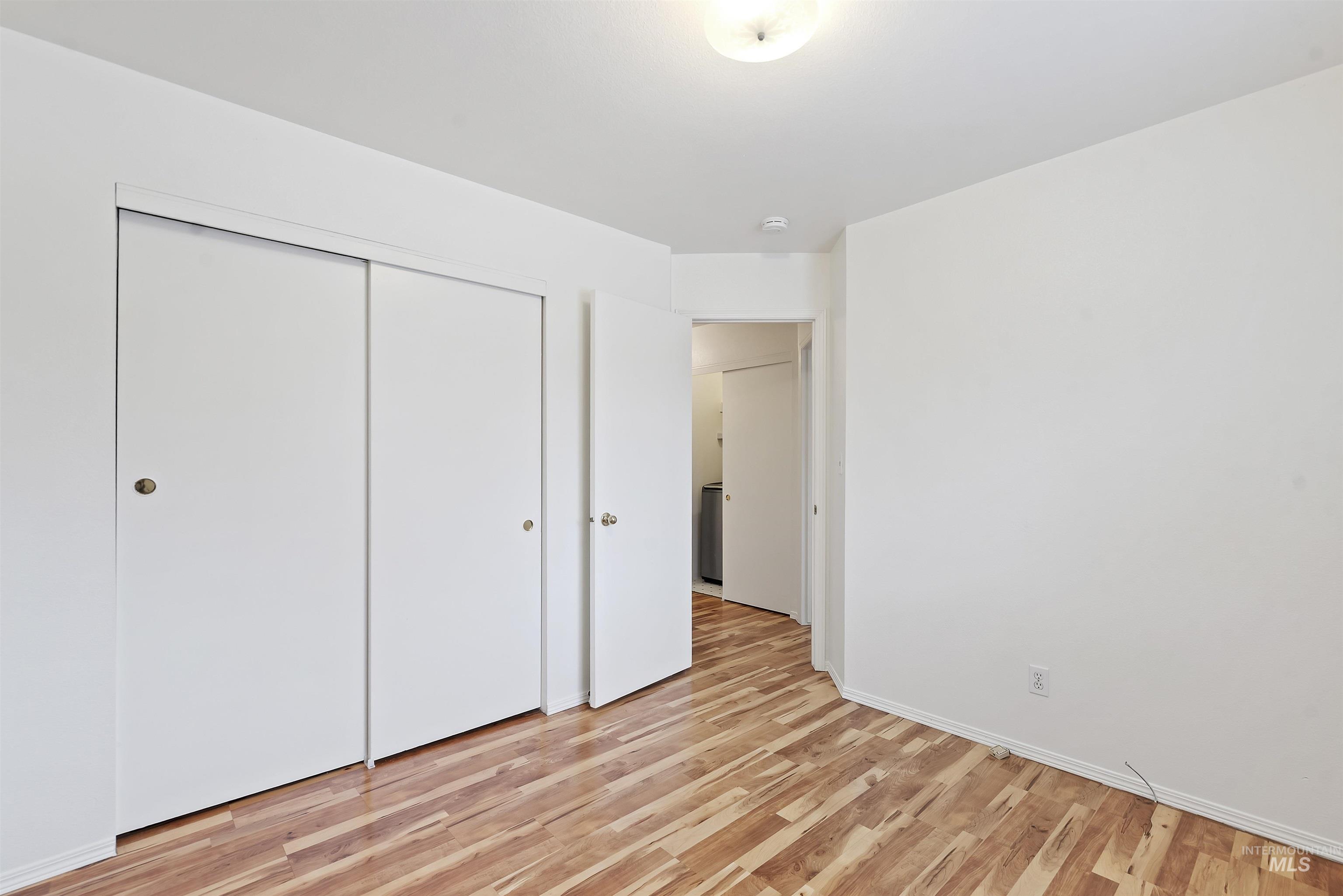 Unfurnished bedroom featuring light wood-type flooring and a closet
