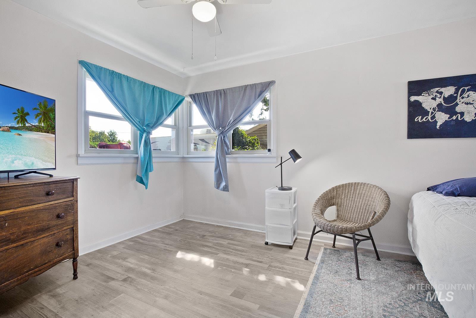 Sitting room featuring healthy amount of natural light, light wood-style floors, and a ceiling fan
