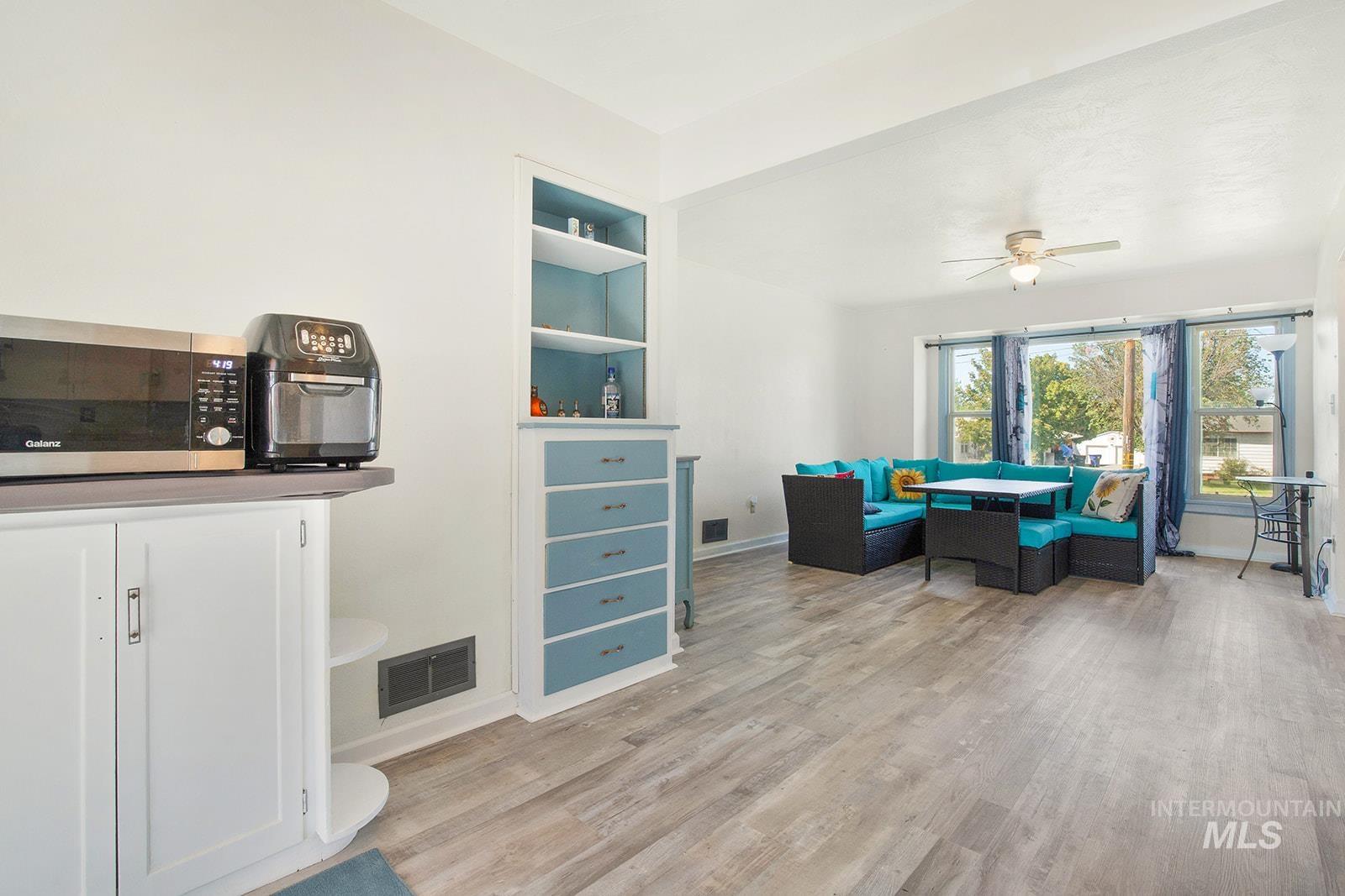 Dining space featuring built in features, light wood-style floors, and a ceiling fan
