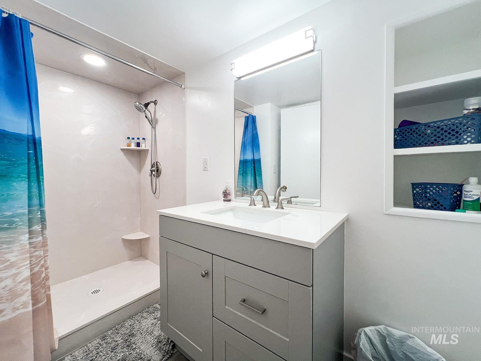 Bathroom featuring vanity, a stall shower, and recessed lighting