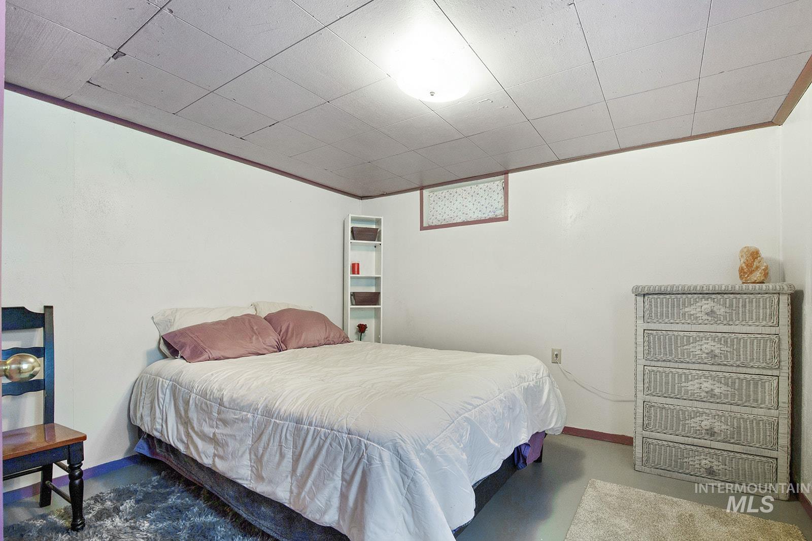 Bedroom with finished concrete floors and ornamental molding