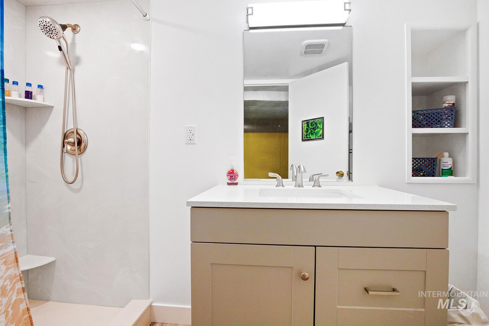 Bathroom with a marble finish shower and vanity
