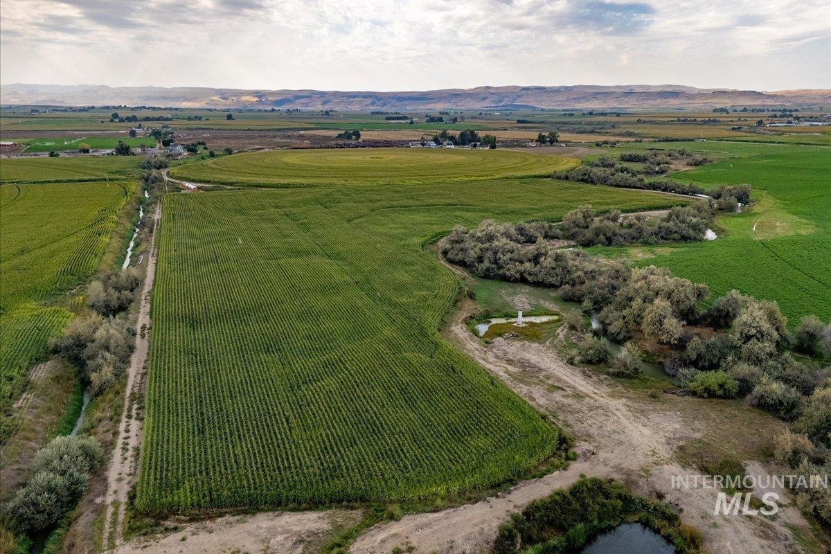 View of rural area featuring large plots for crops and a mountainous background