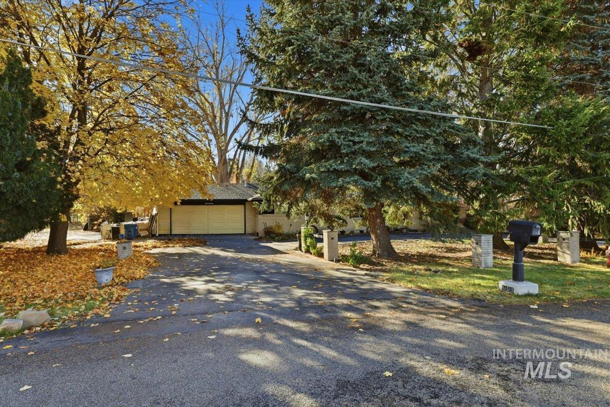Obstructed view of property with a garage and asphalt driveway