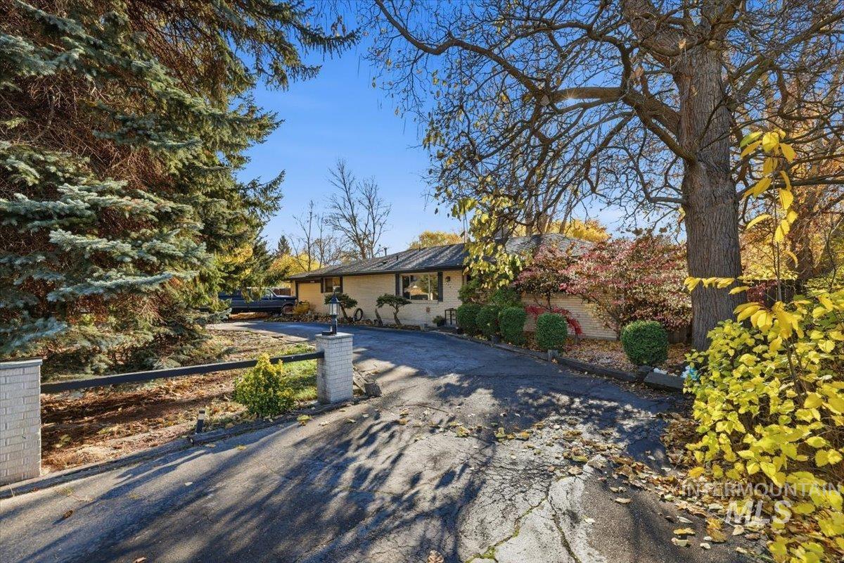 Ranch-style house with asphalt driveway and brick siding