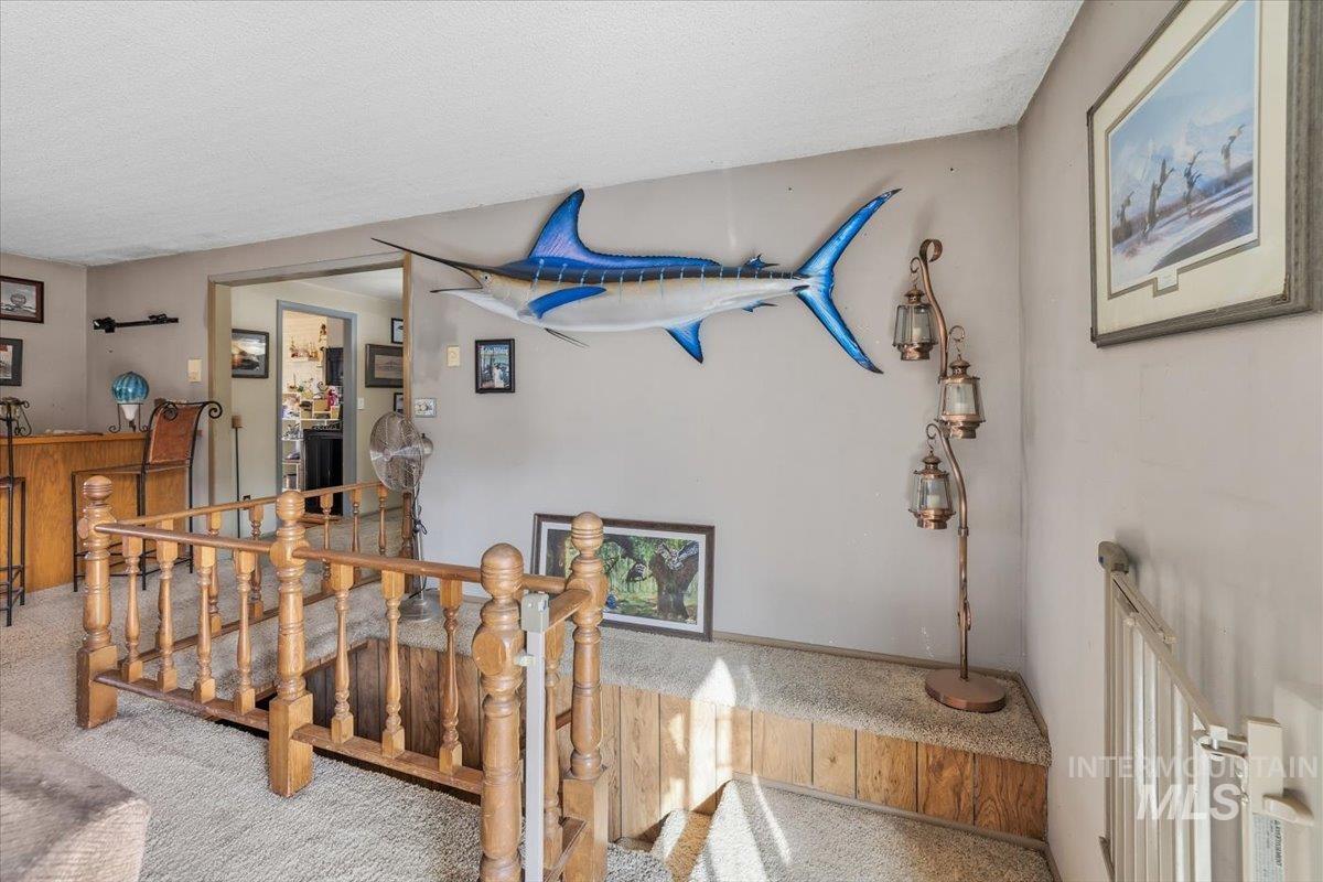 Stairs with carpet floors and a textured ceiling
