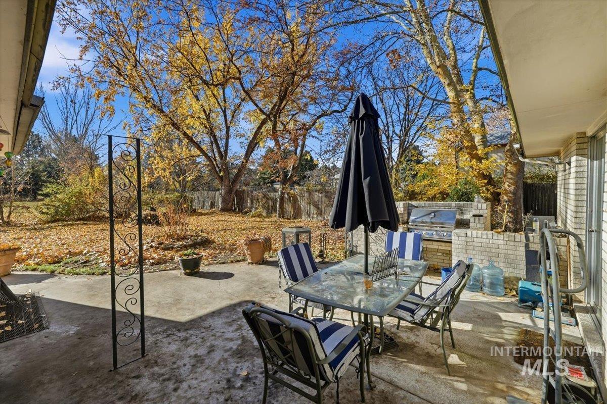Fenced backyard featuring a patio area, outdoor dining area, and an outdoor kitchen