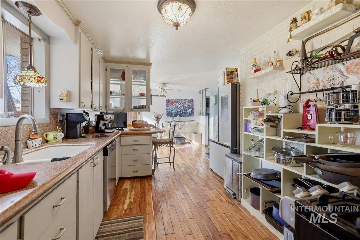 Kitchen with decorative light fixtures, healthy amount of natural light, light wood-style floors, and freestanding refrigerator