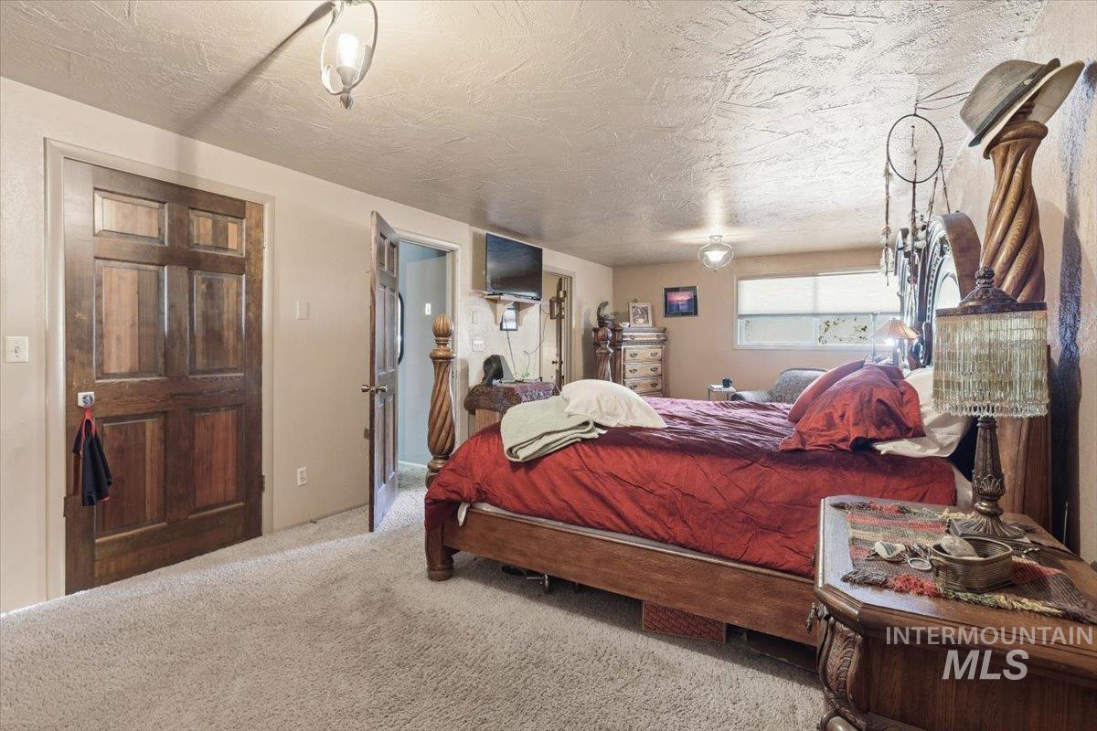 Carpeted bedroom featuring a textured ceiling