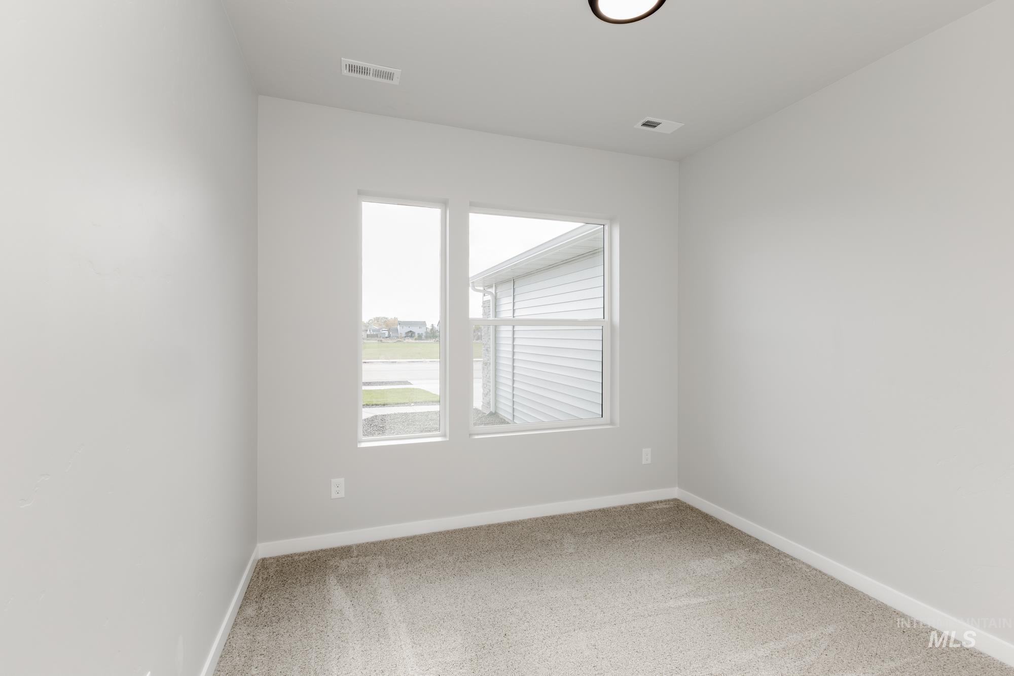 Unfurnished room with baseboards and light colored carpet