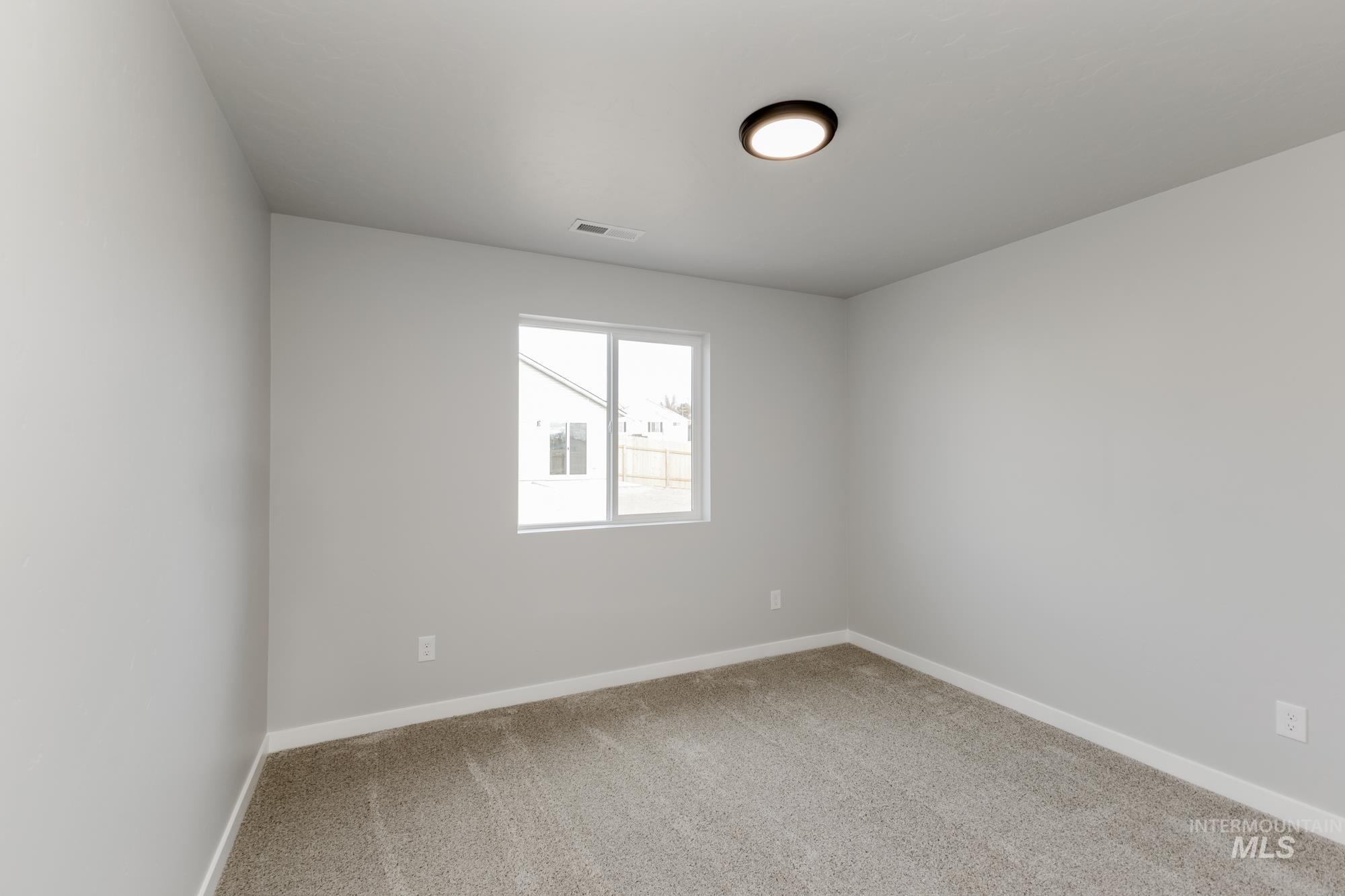 Empty room with light carpet and baseboards