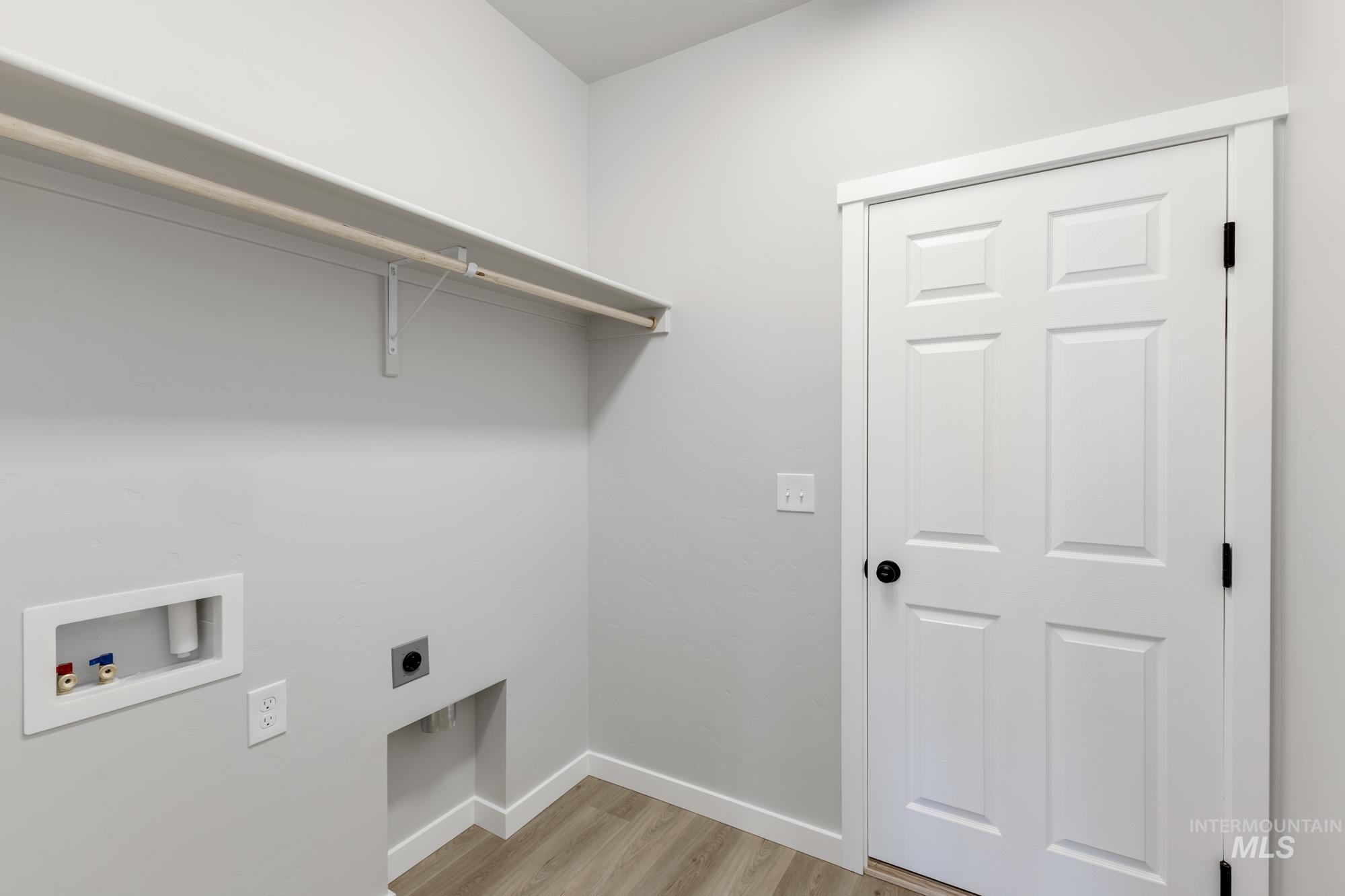 Laundry area with electric dryer hookup, washer hookup, and light wood finished floors