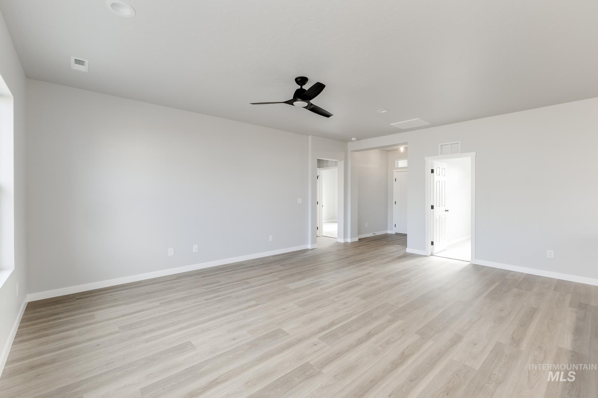 Spare room with a ceiling fan and light wood-type flooring