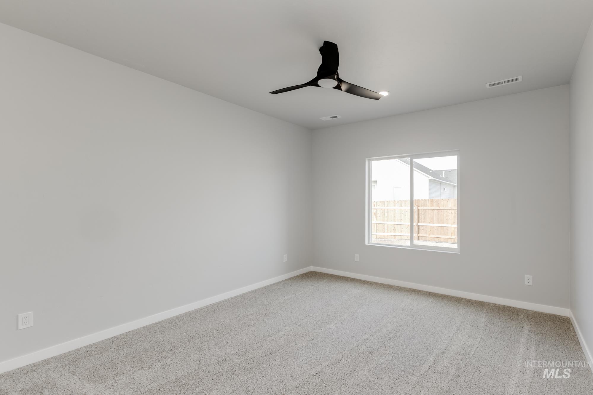 Spare room featuring light carpet and a ceiling fan