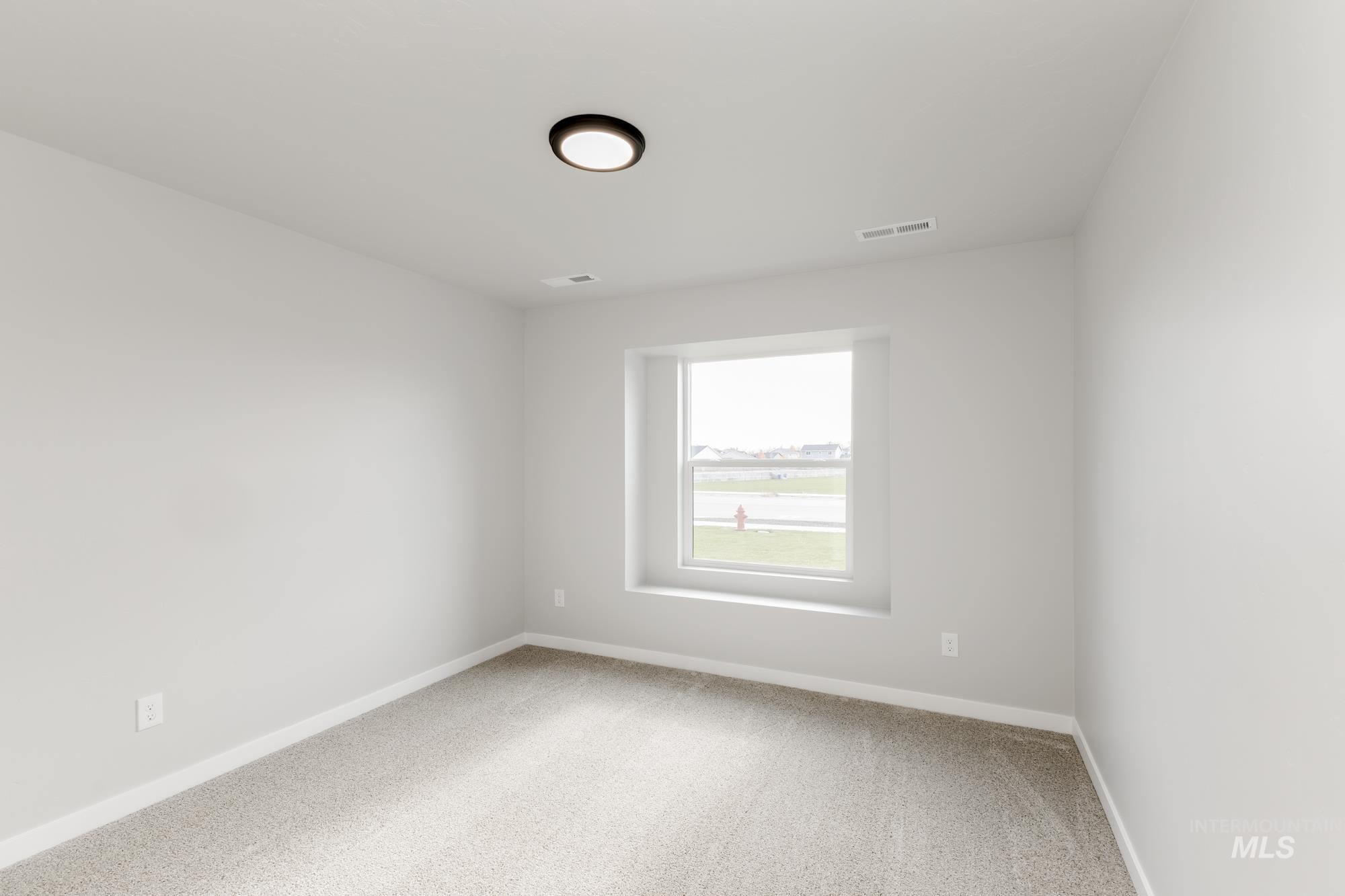 Carpeted empty room featuring baseboards
