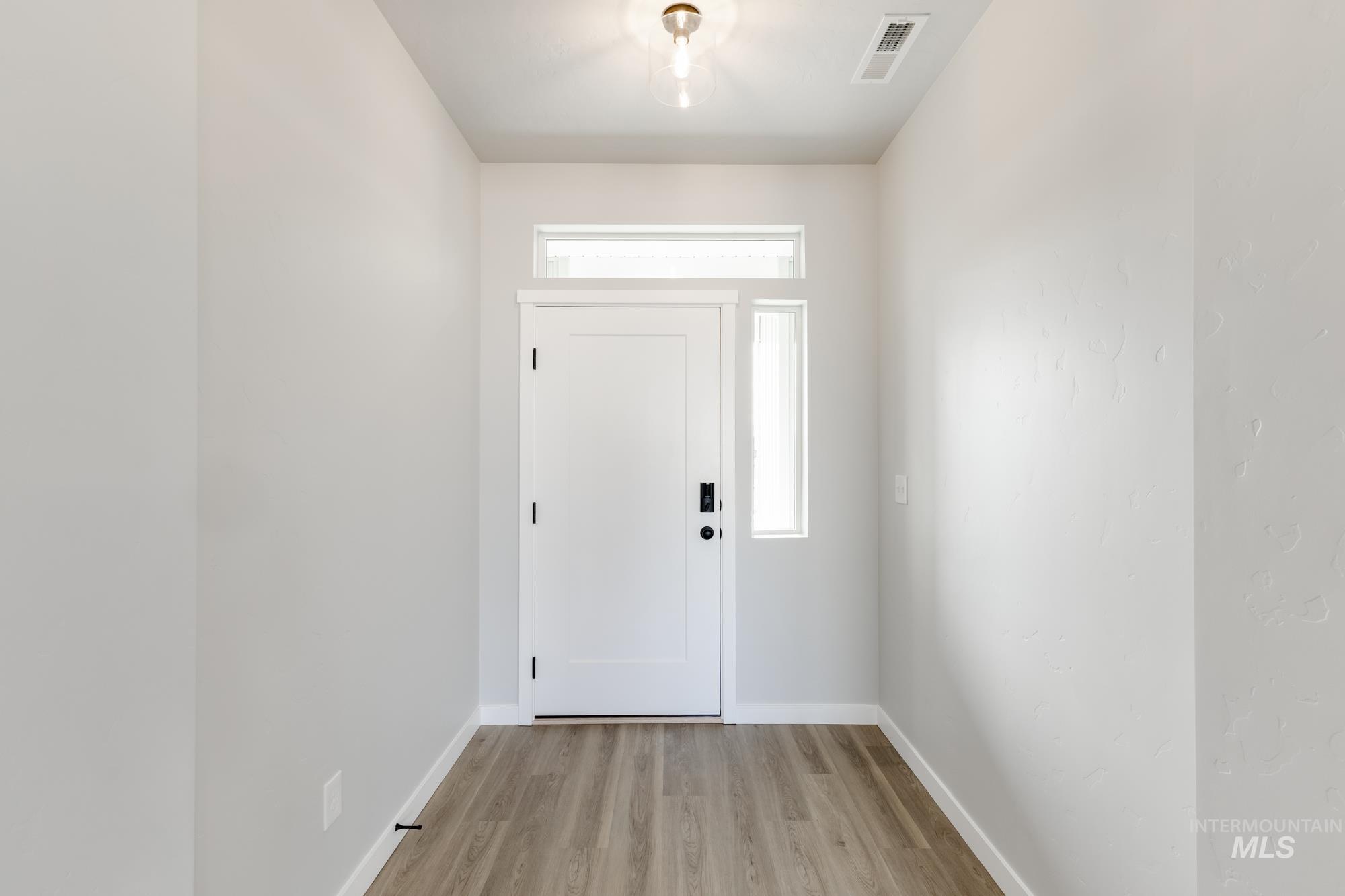 Entryway with light wood-style flooring and baseboards