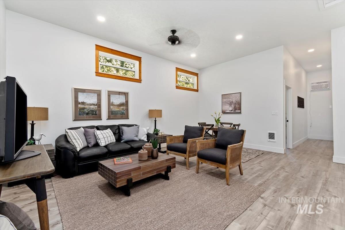 Living area with light wood-style flooring, recessed lighting, and a ceiling fan